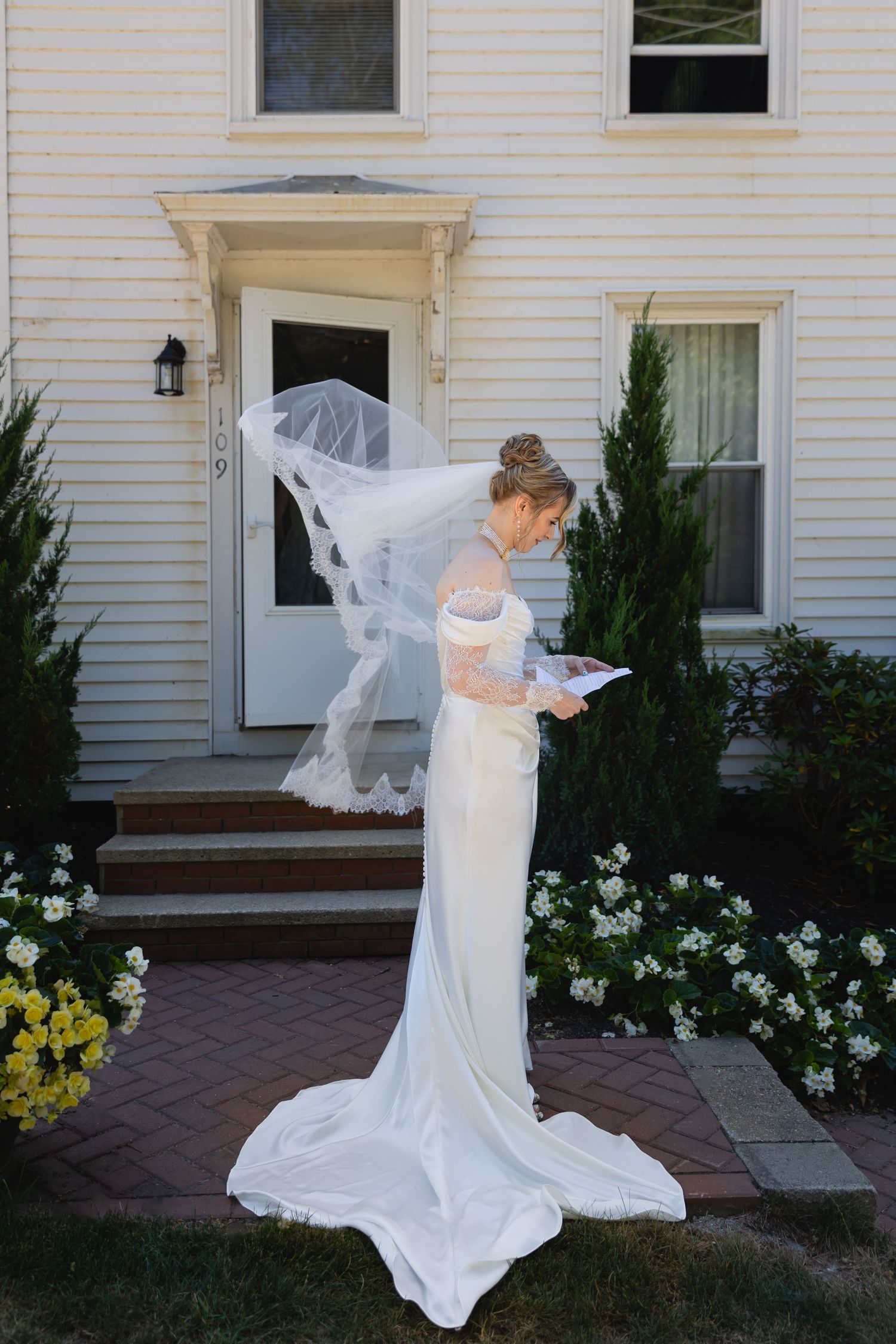 A series of photos showing a bride in a flowing white wedding dress and veil walking along a brick pathway outside a house.