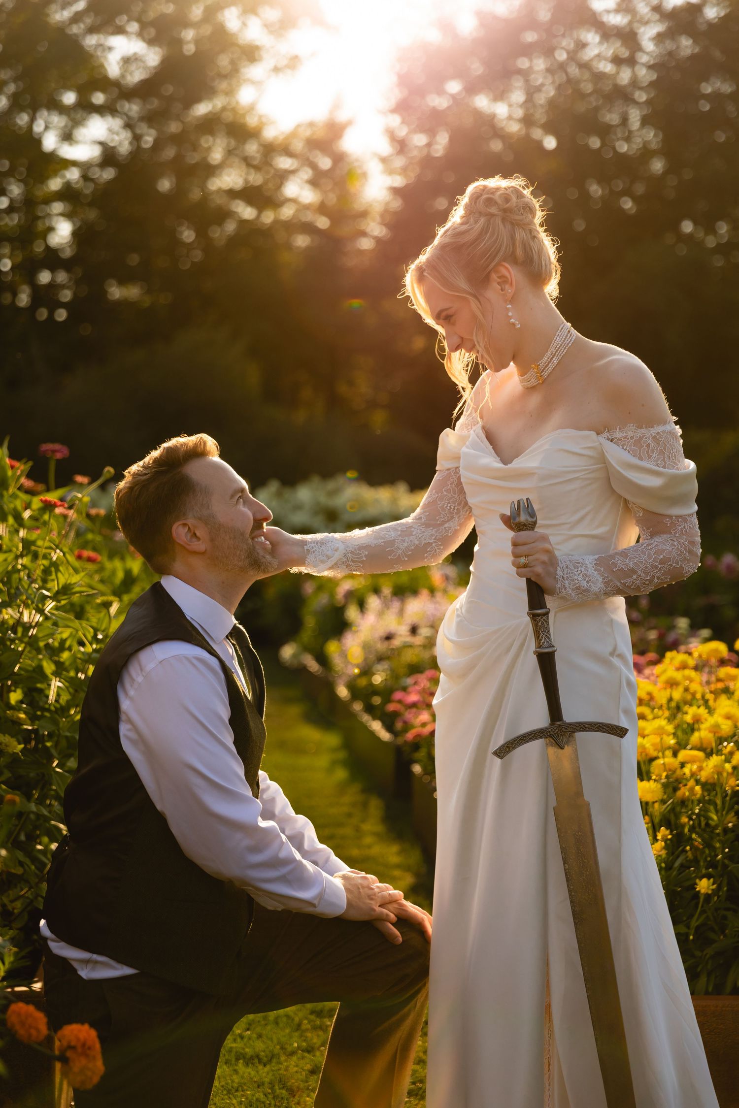 A romantic sunset engagement session in a garden with golden light streaming through blooming flowers and greenery.