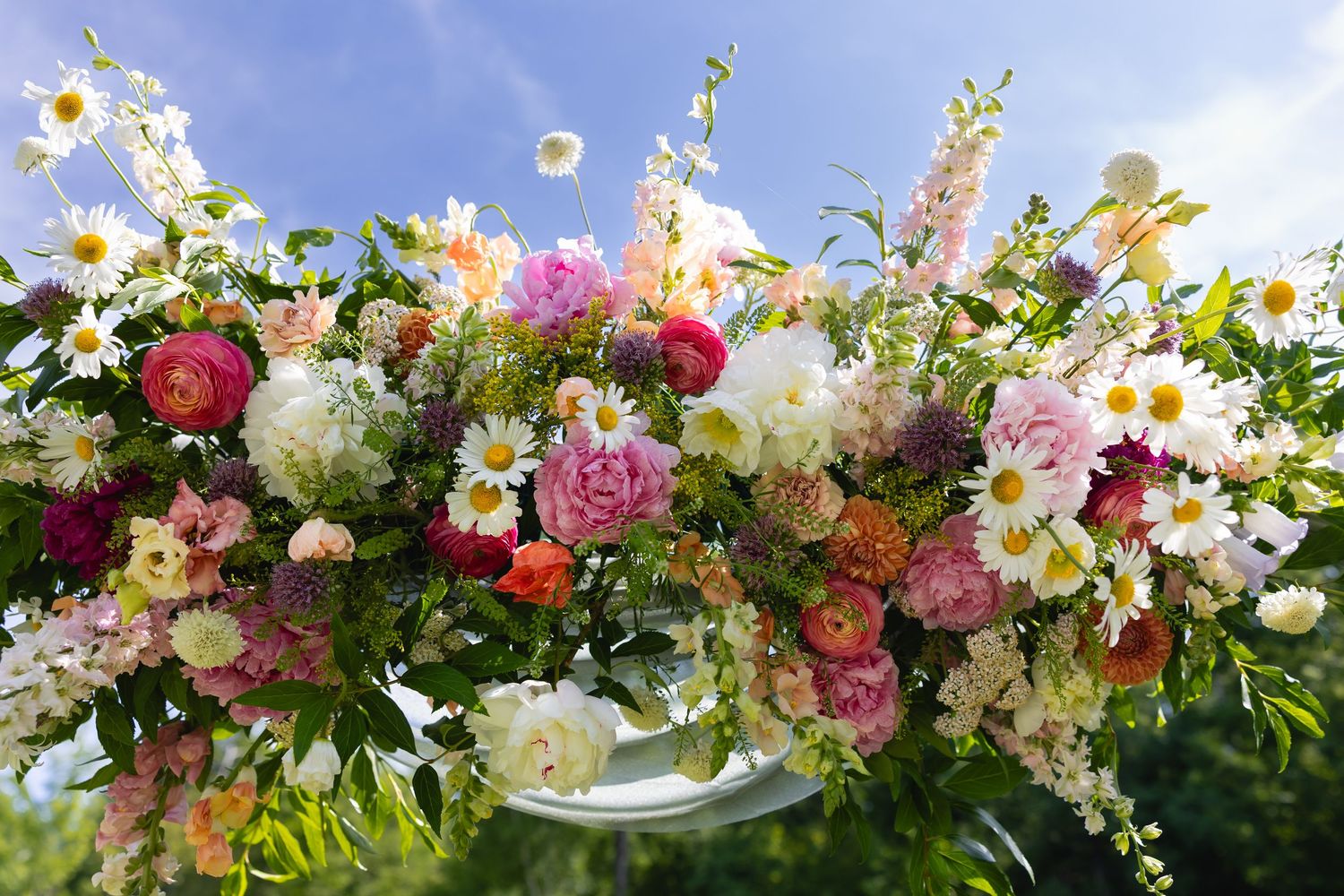 Colorful floral garland with fresh pink, white, and yellow blooms arranged in a lush decorative border design.