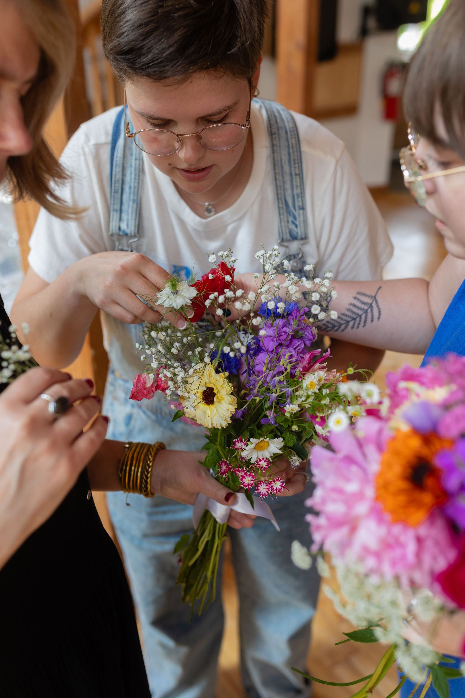 People arranging colorful wildflowers and creating bouquets together with fresh blooms.