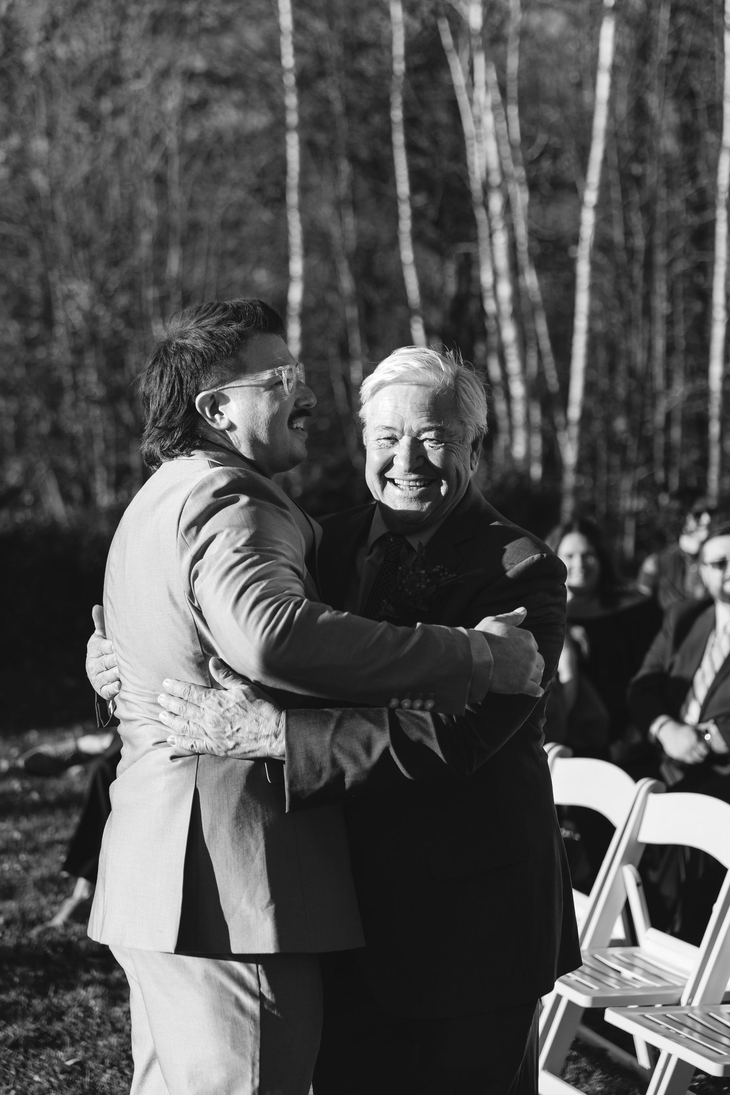 Emotional moment shared between wedding attendees during outdoor autumn ceremony.