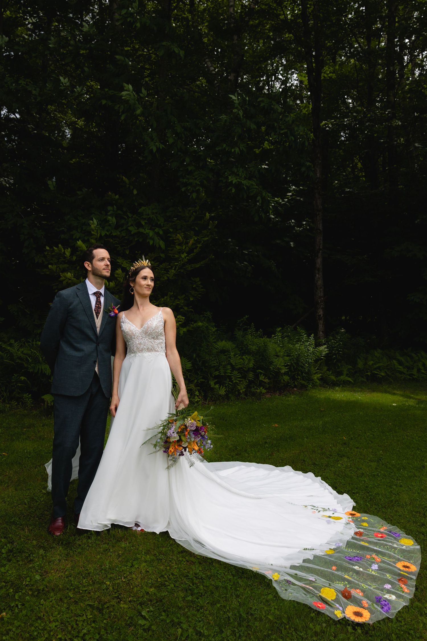 Wedding couple in outdoor garden wearing elegant attire with beautifully decorated floral train.