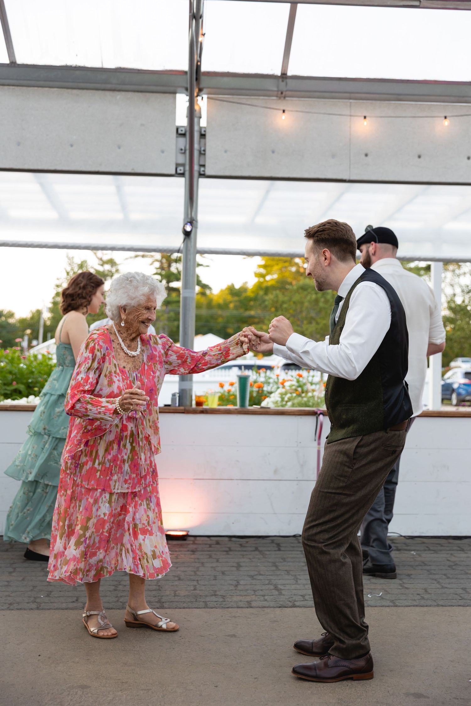 A sequence of dance moves showing a couple swaying together under a white tent during a celebration.
