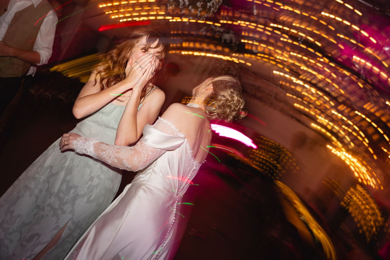A dance floor illuminated with golden and pink lights creates a warm celebratory atmosphere.