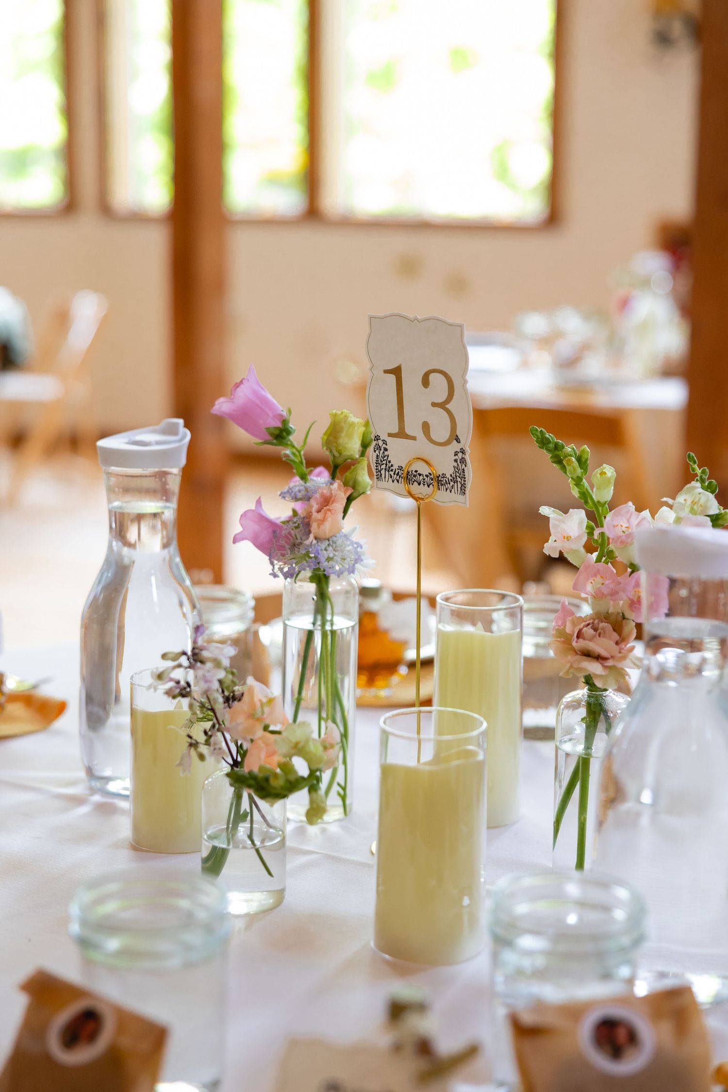 Wedding reception table decorated with glass jars filled with lemonade and delicate floral arrangements.