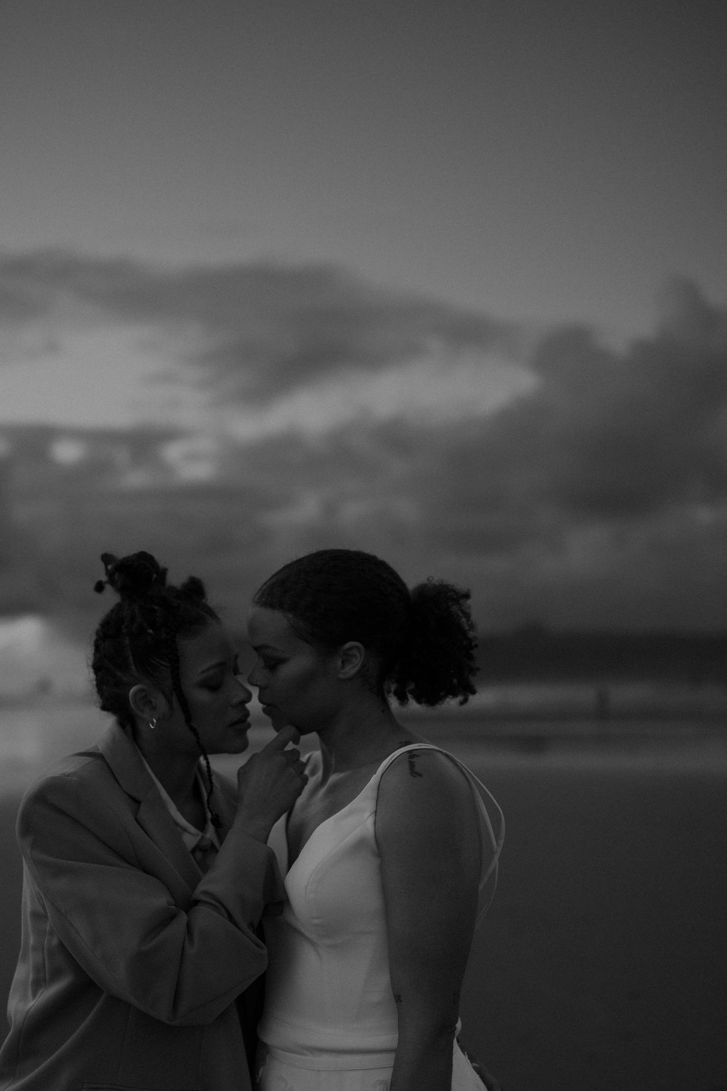 An intimate close-up of a romantic couple sharing a tender moment at sunset on a beach.