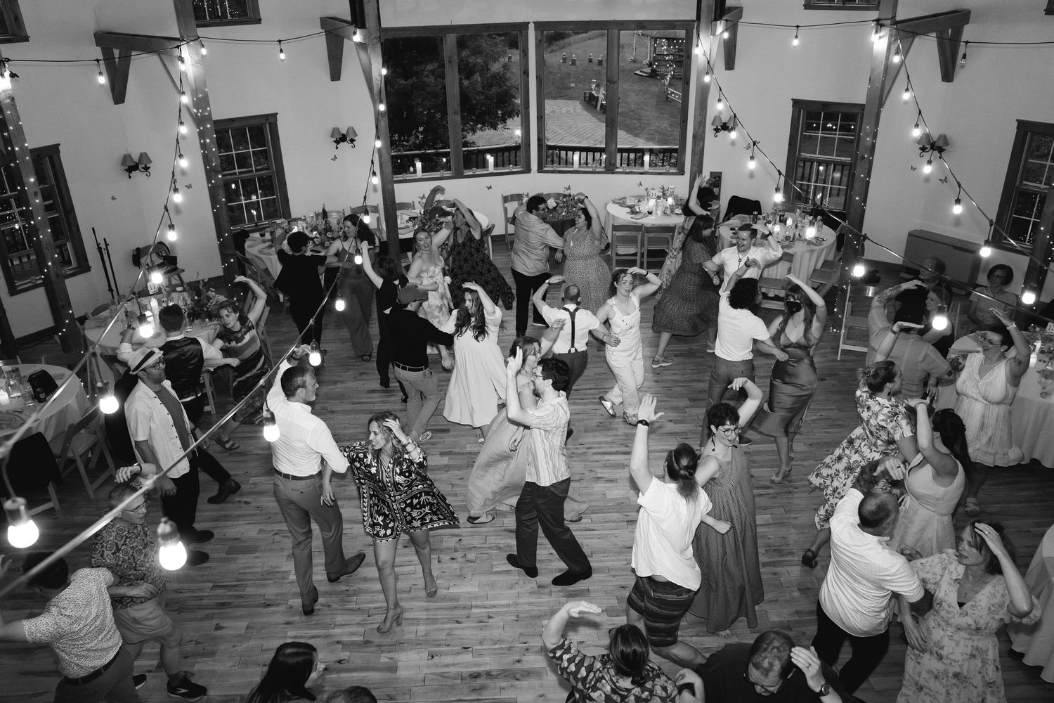 People dancing together at a social gathering in what appears to be a community hall or dance studio.