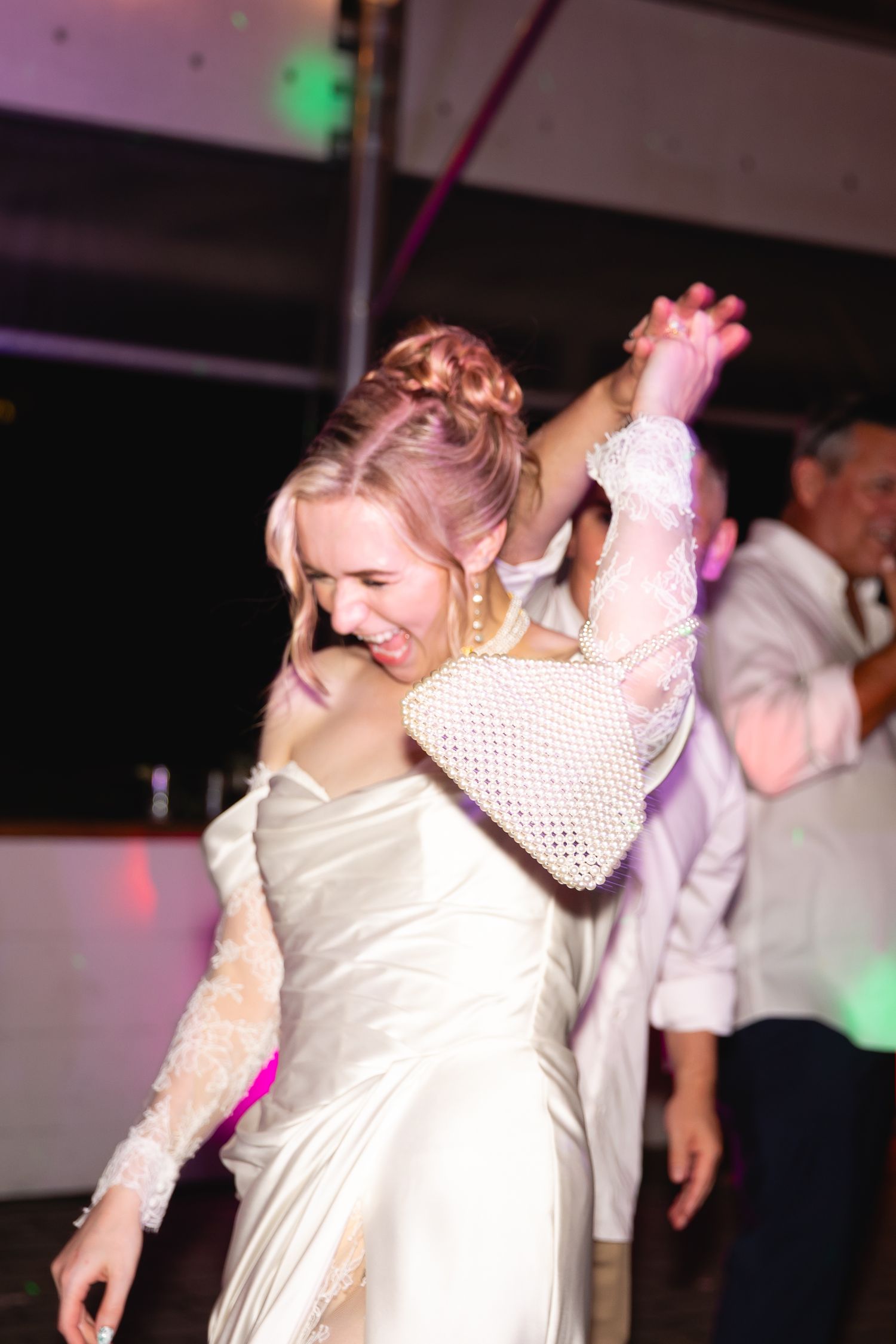 A sequence of dance photos showing people in white outfits moving energetically on a dimly lit dance floor with purple lighting.