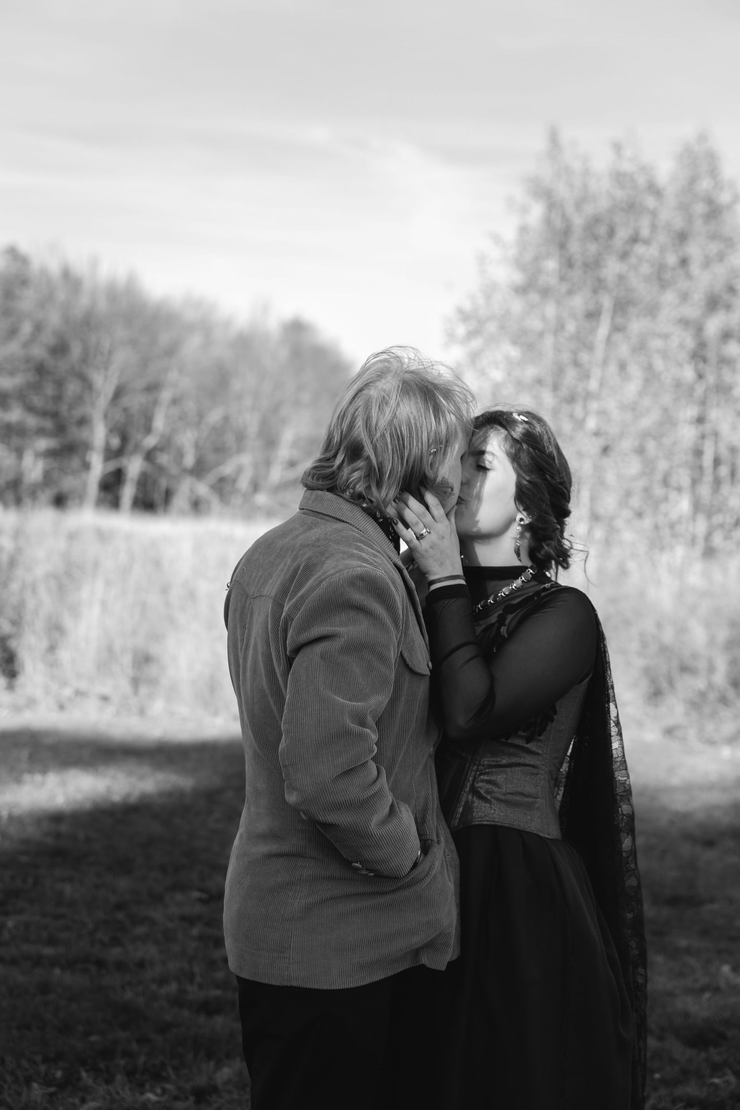 A romantic black and white photo sequence showing a couple embracing and kissing in a nature setting.