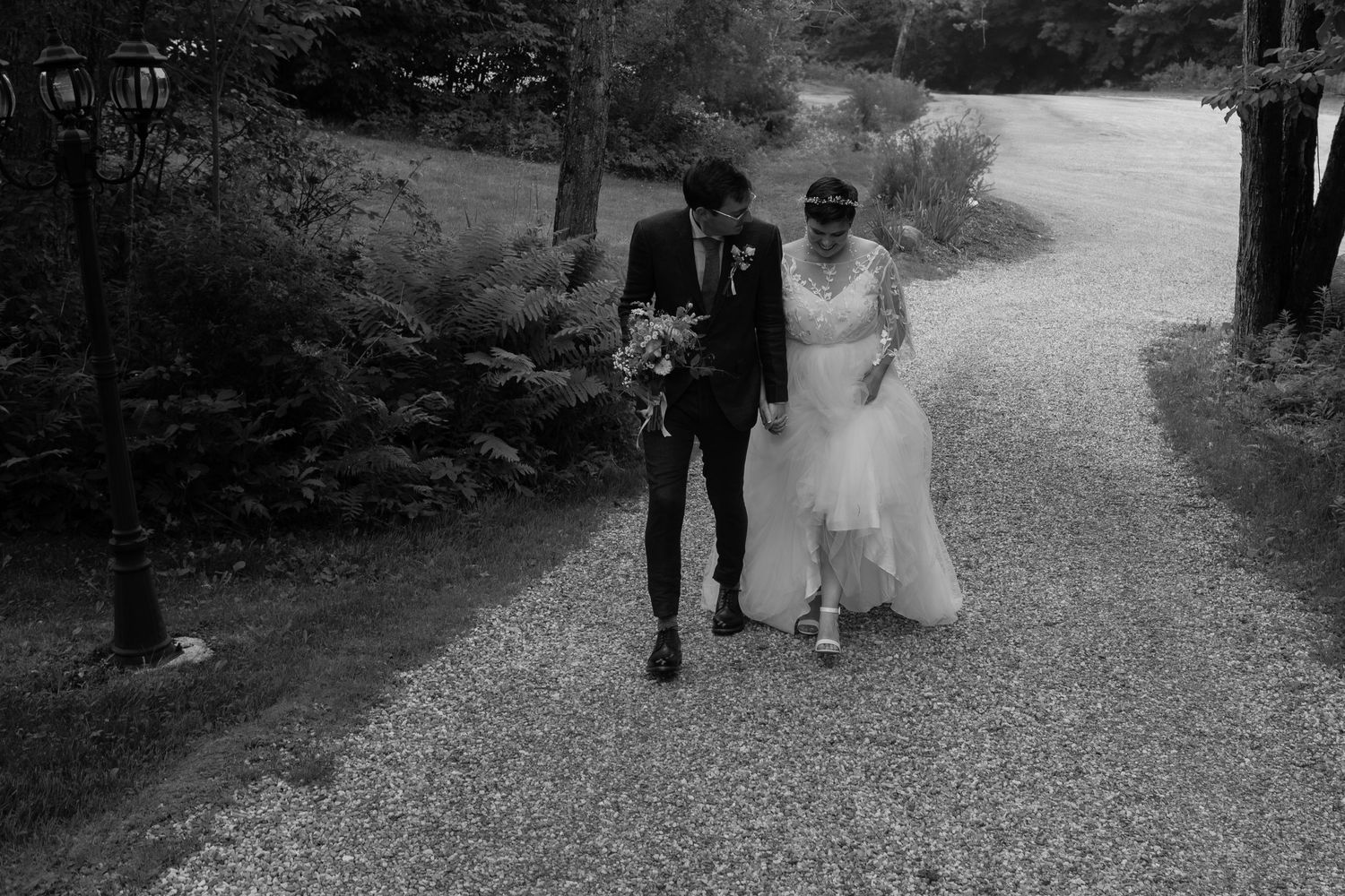 Black and white photograph of couple walking together on garden path.