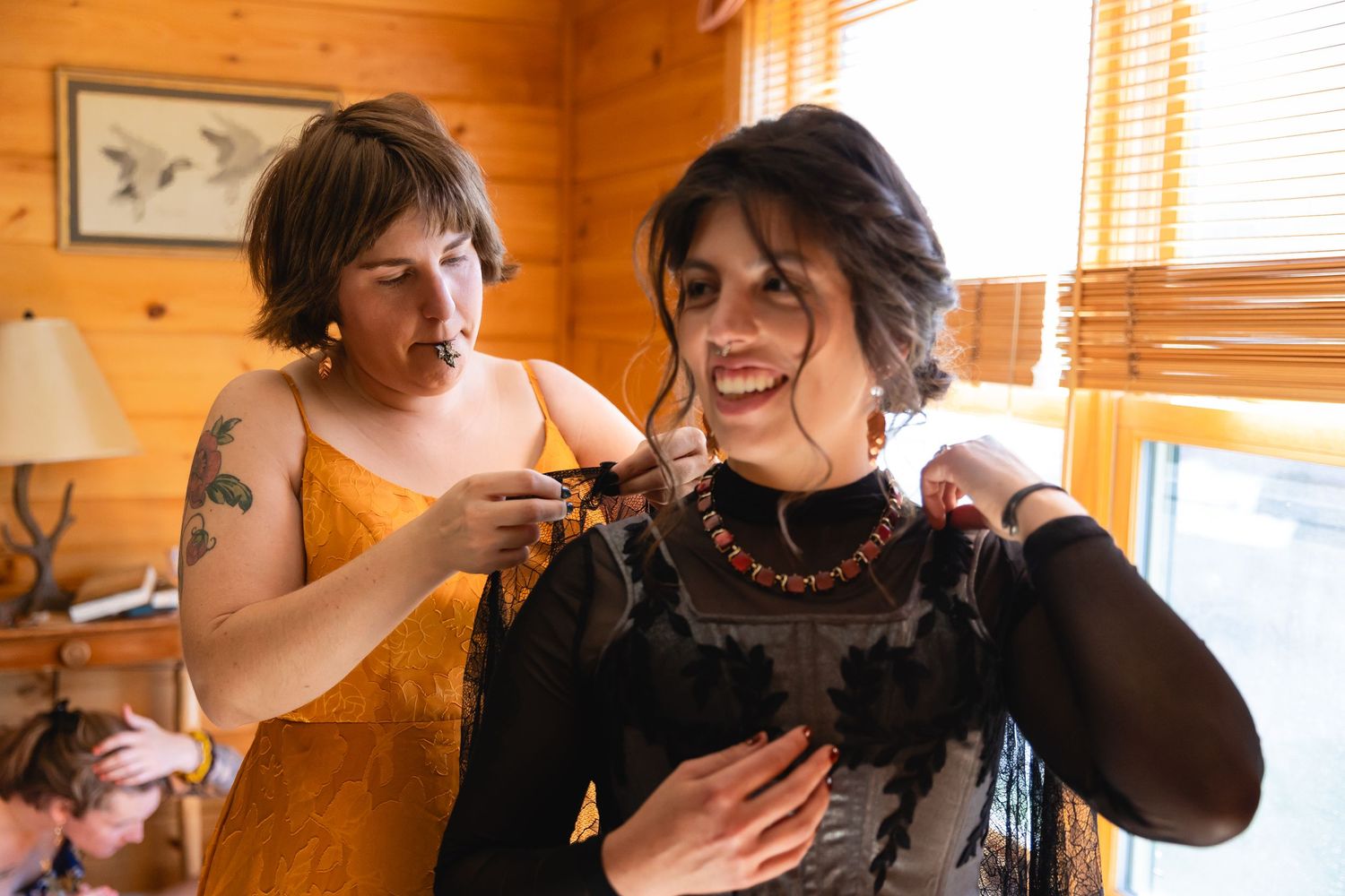 Two people share an intimate moment while dancing together in a rustic wooden cabin interior.
