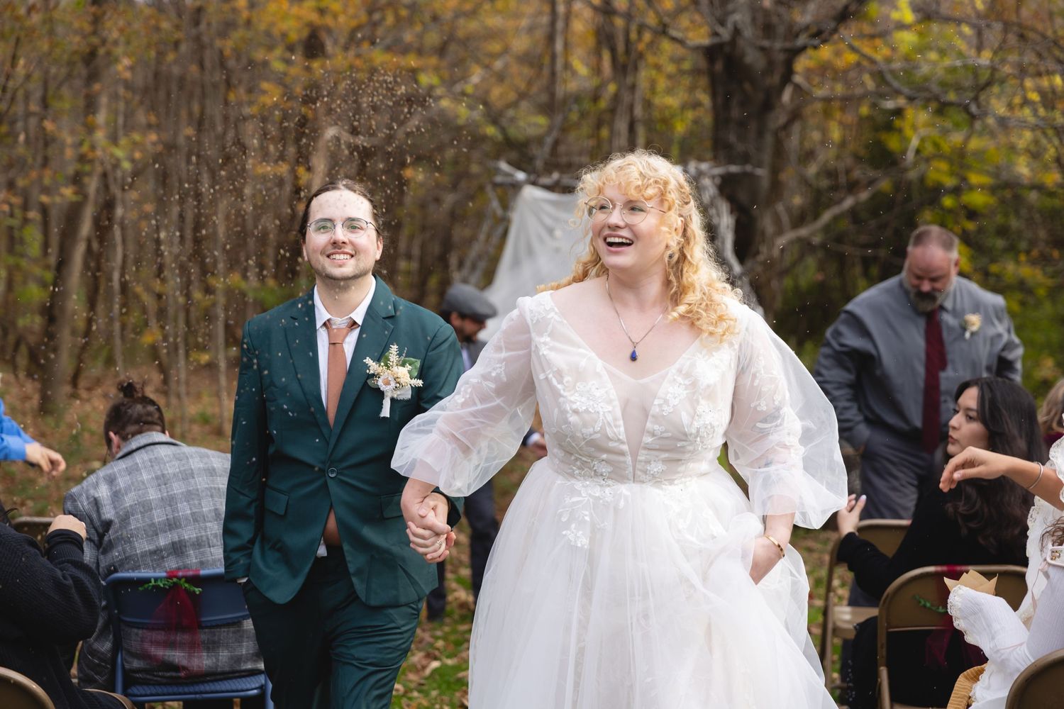 Joyful celebration at an outdoor autumn wedding with white tent backdrop.