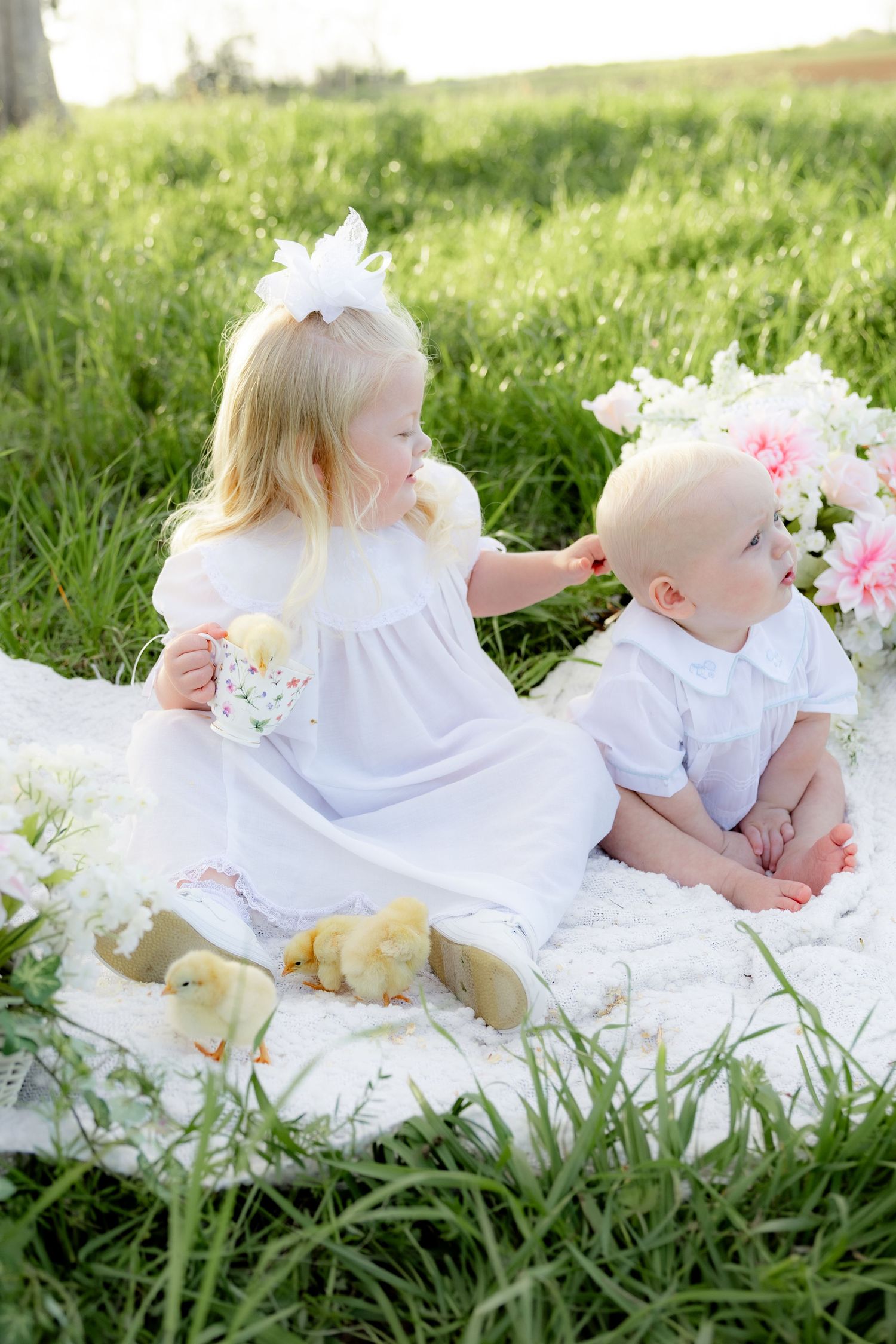 Spring Mini Session with baby chicks in a grass field at sunset near Dothan, Alabama