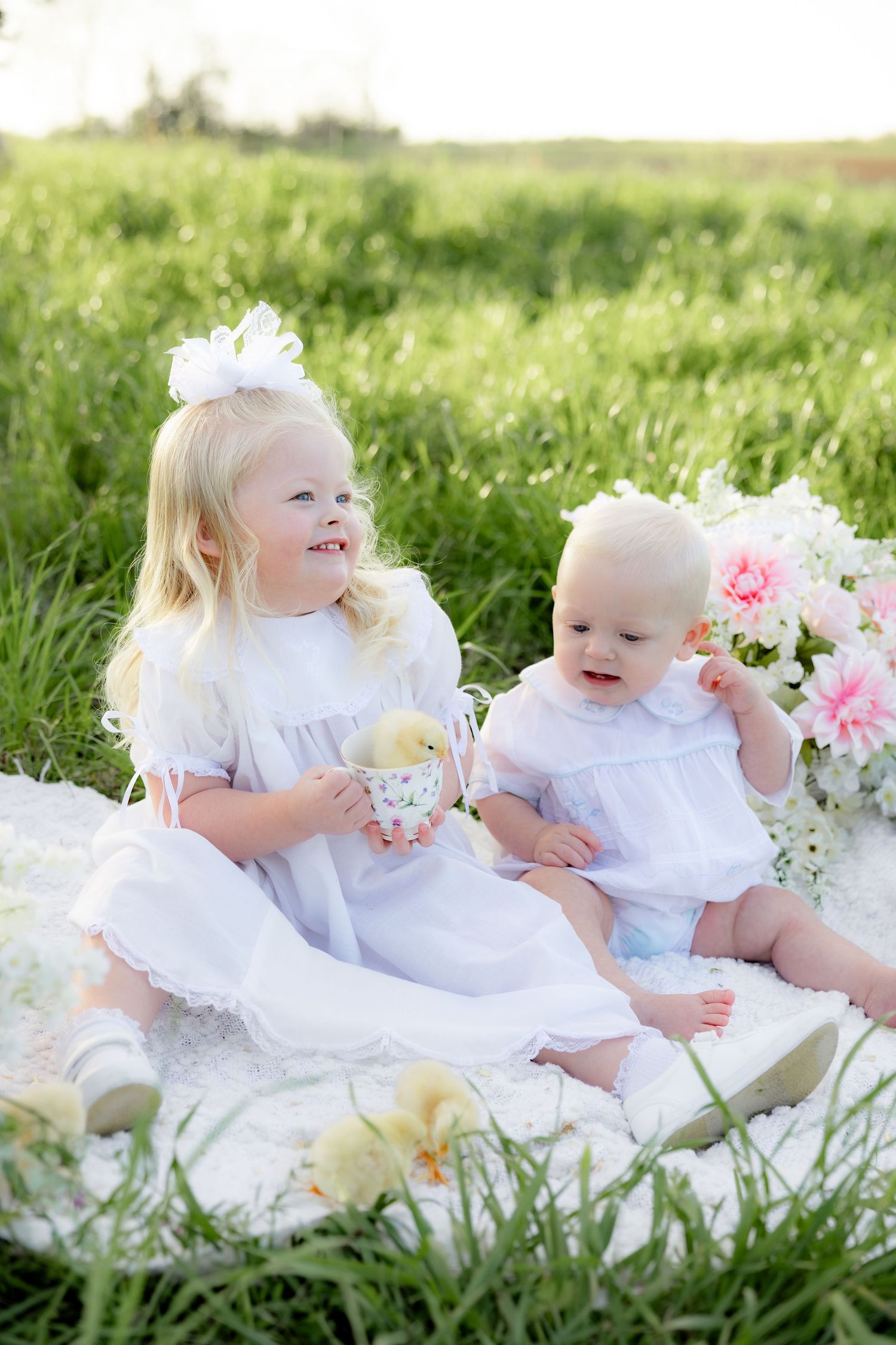 Spring Mini Session with baby chicks in a grass field at sunset near Dothan, Alabama