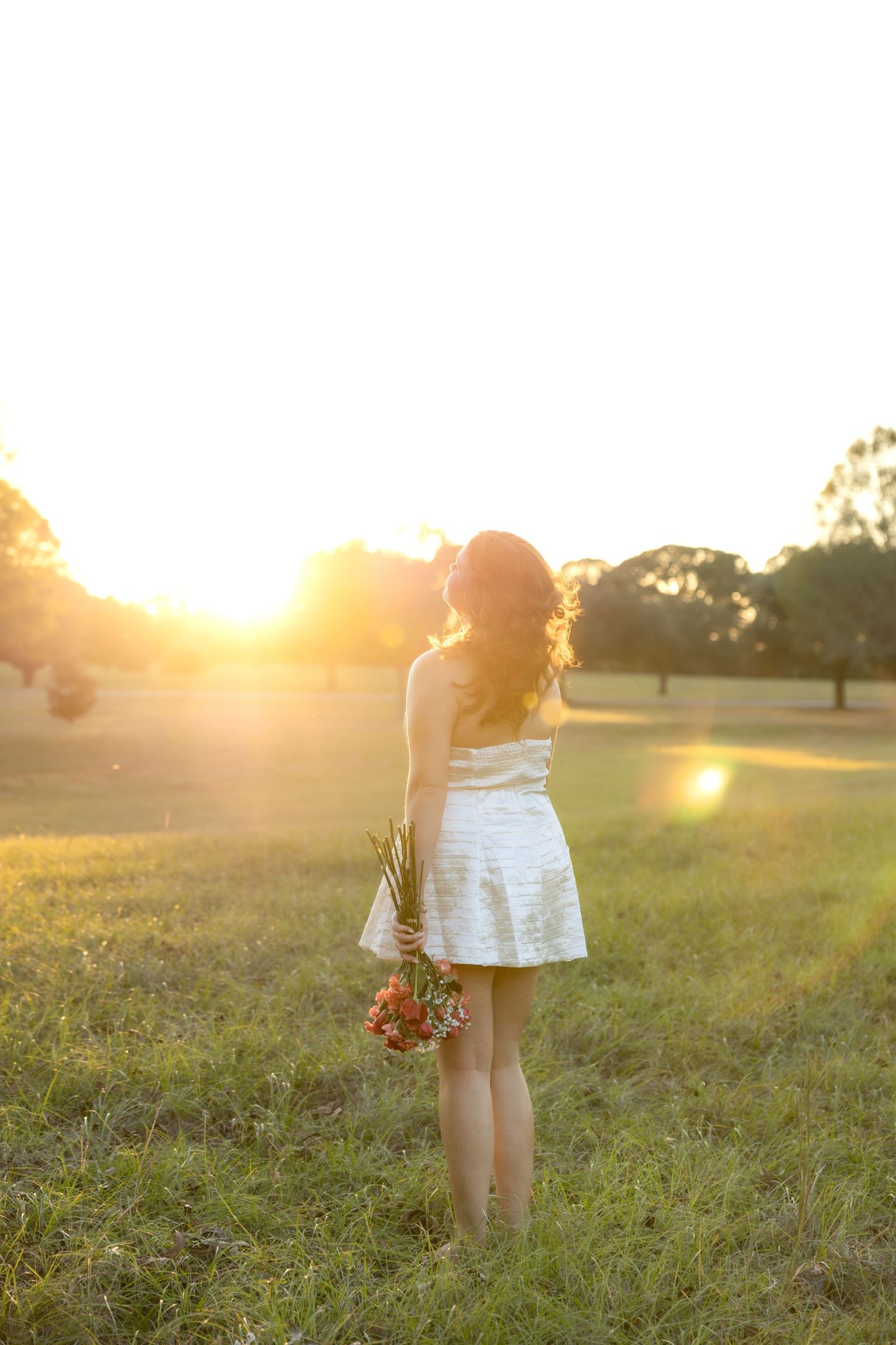 Senior pictures in a field at sunset at Troy University Dothan Campus