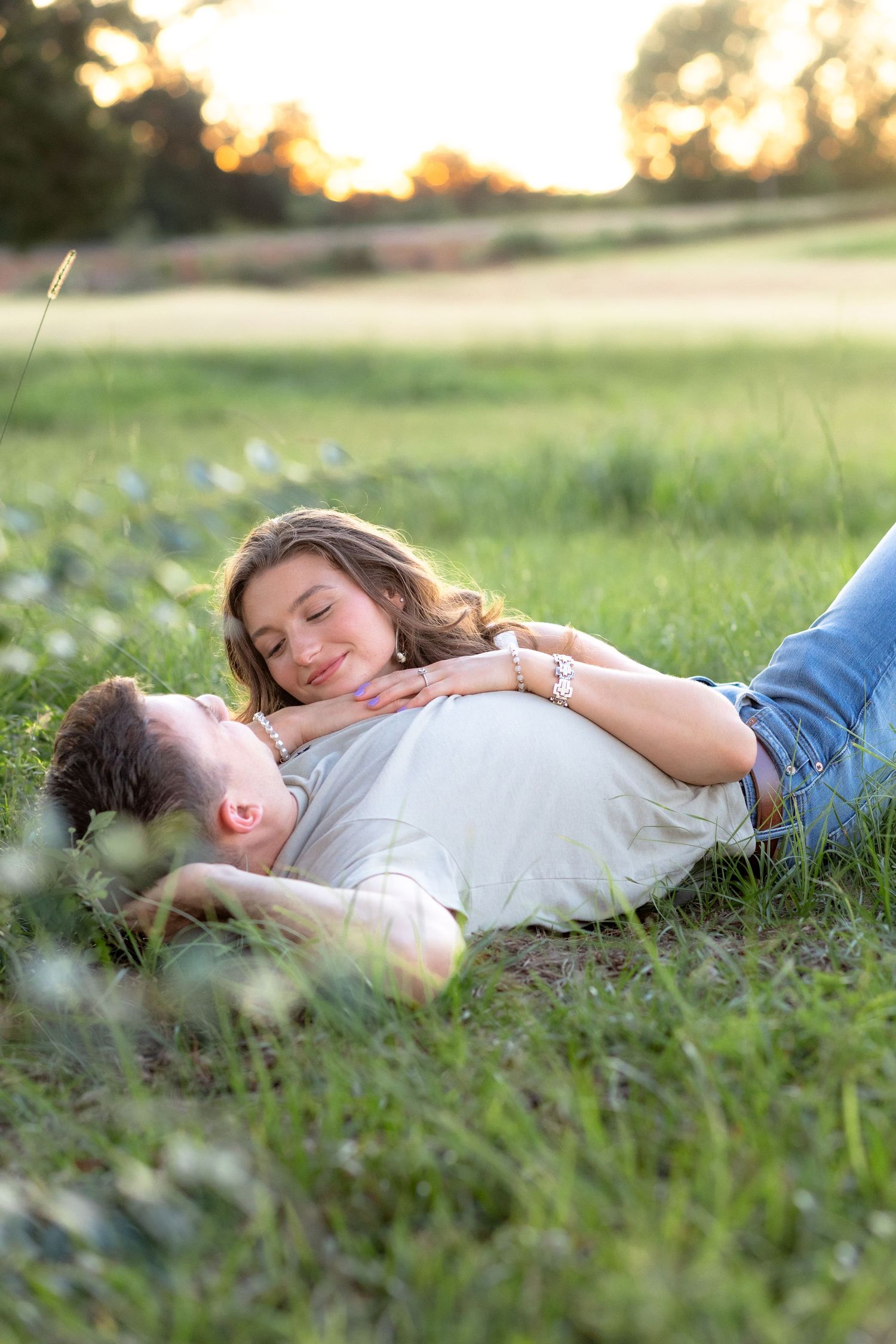 Couple laying in a grass field in Dothan, Alabama