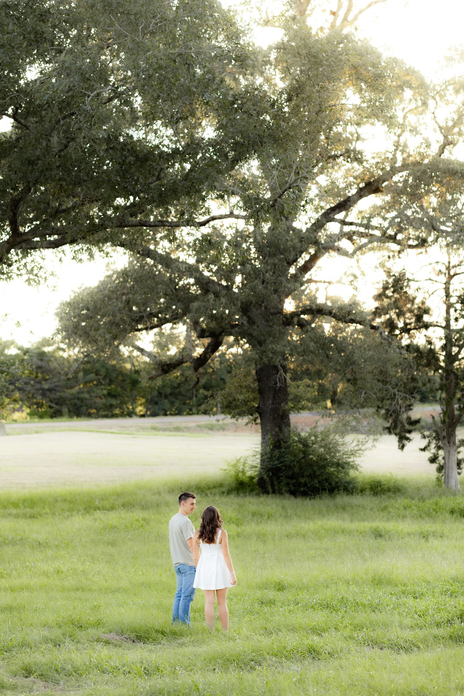 Couple holding each other in a grass field at sunset in Dothan, Alabama