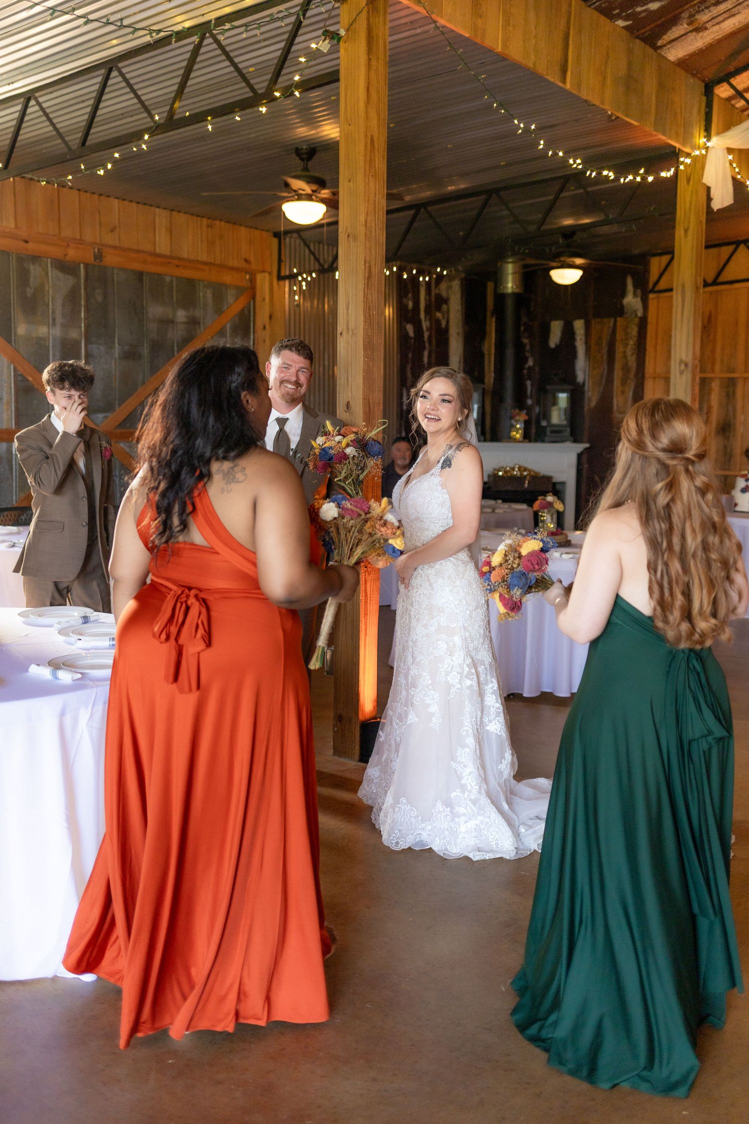 Bride and groom celebrating with their bridal party in the barn of Hilltop Acres Dothan, Alabama