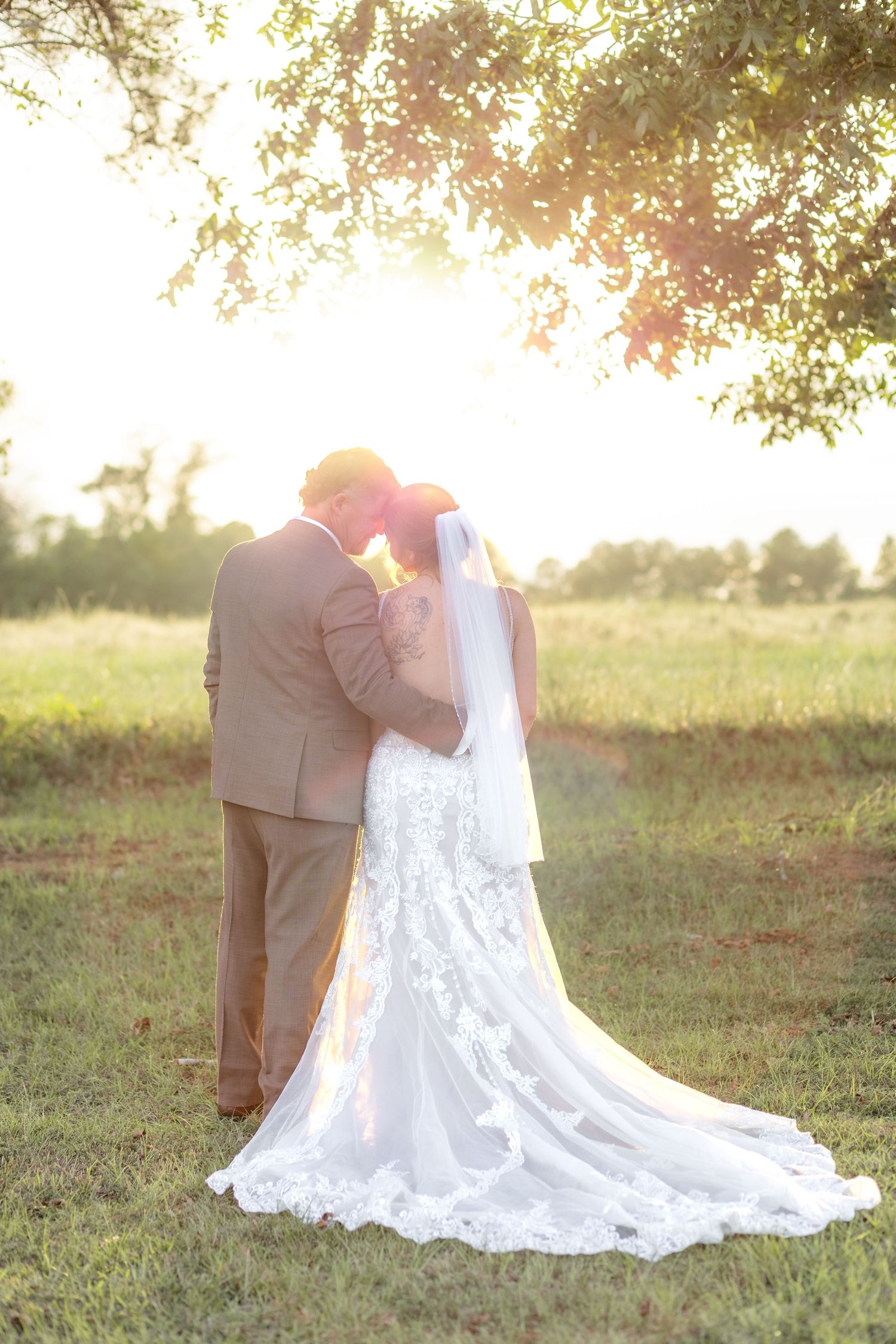 Bride and groom hold each other at sunset at Hilltop Acres Wicksburg, Alabama