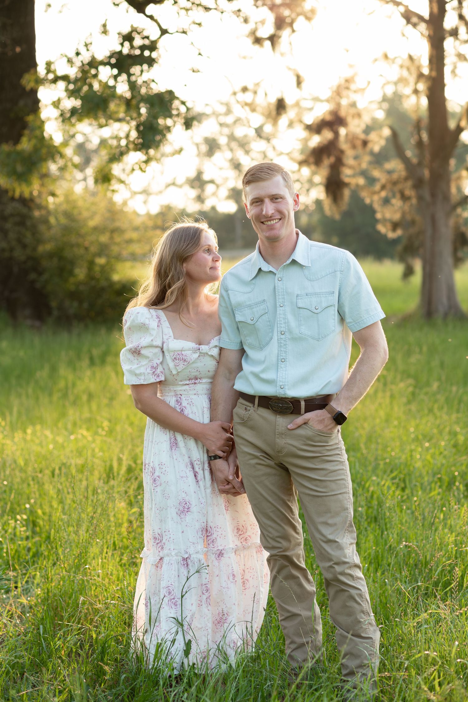 Couple standing in a grass field at sunset in Dothan, Alabama