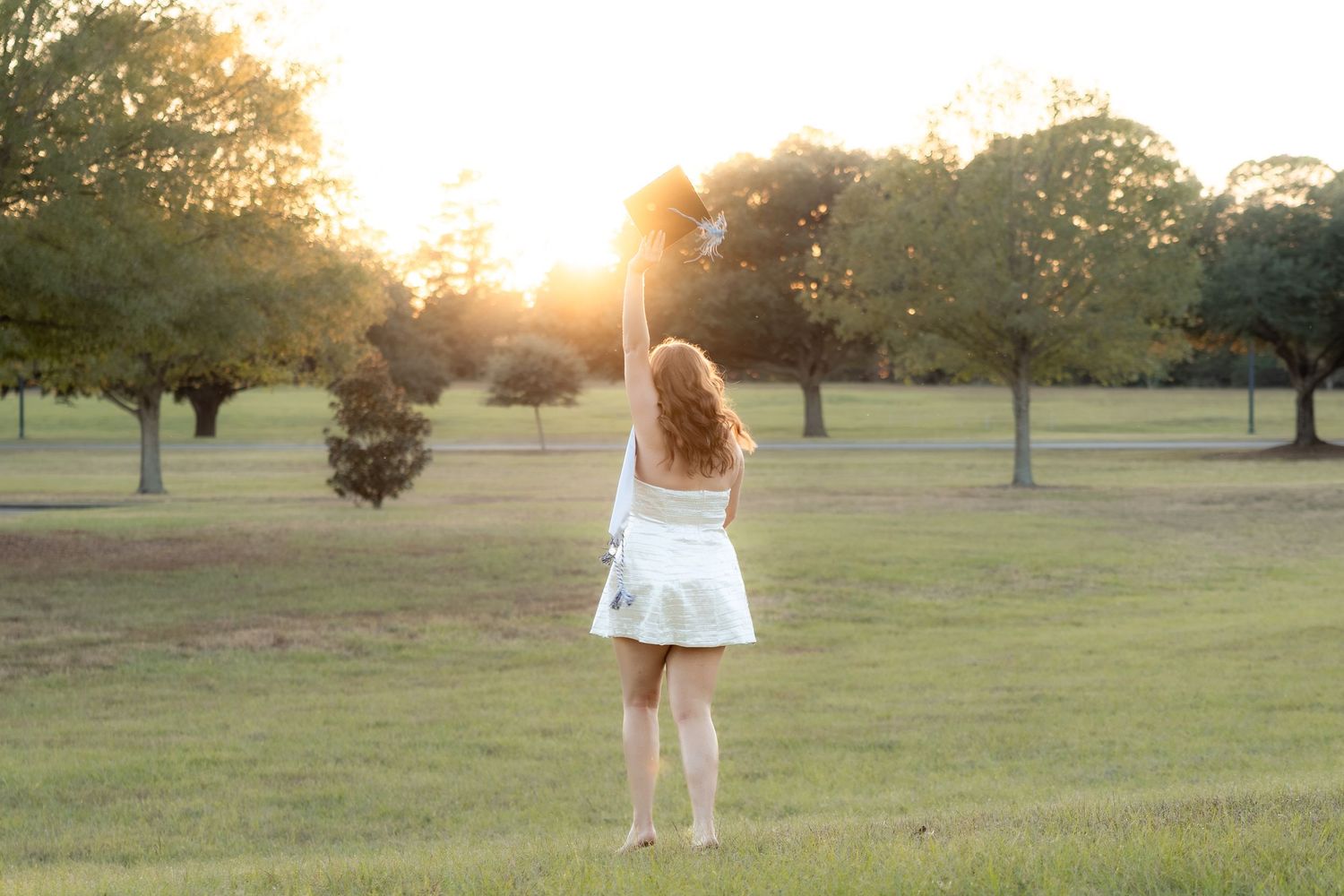 Senior running through a field at sunset at Troy University Dothan Campus
