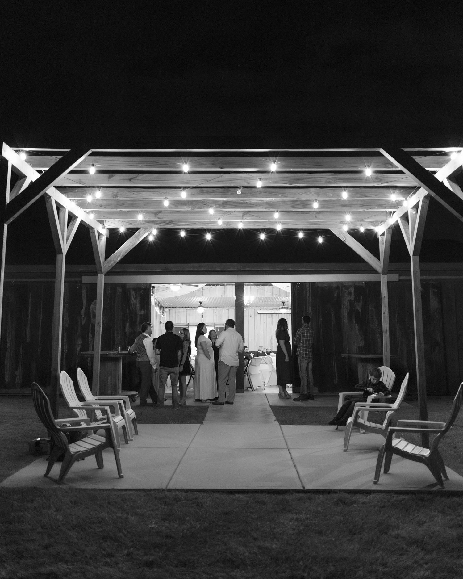 Guests at a wedding mingle underneath the gazebo at Hilltop Acres Wicksburg, Alabama