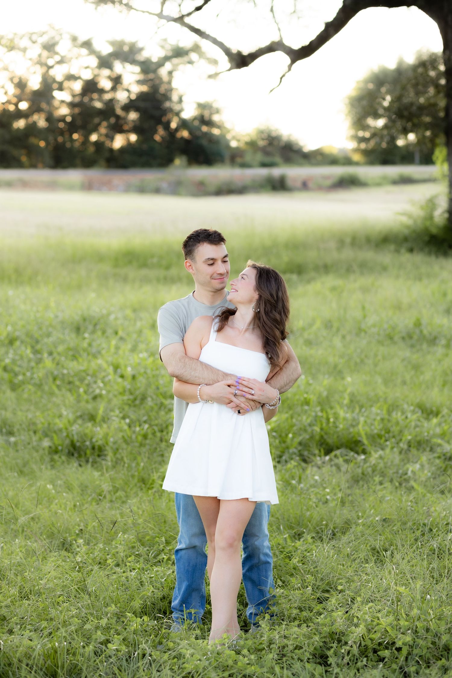 Couple holding each other in a grass field at sunset in Dothan, Alabama