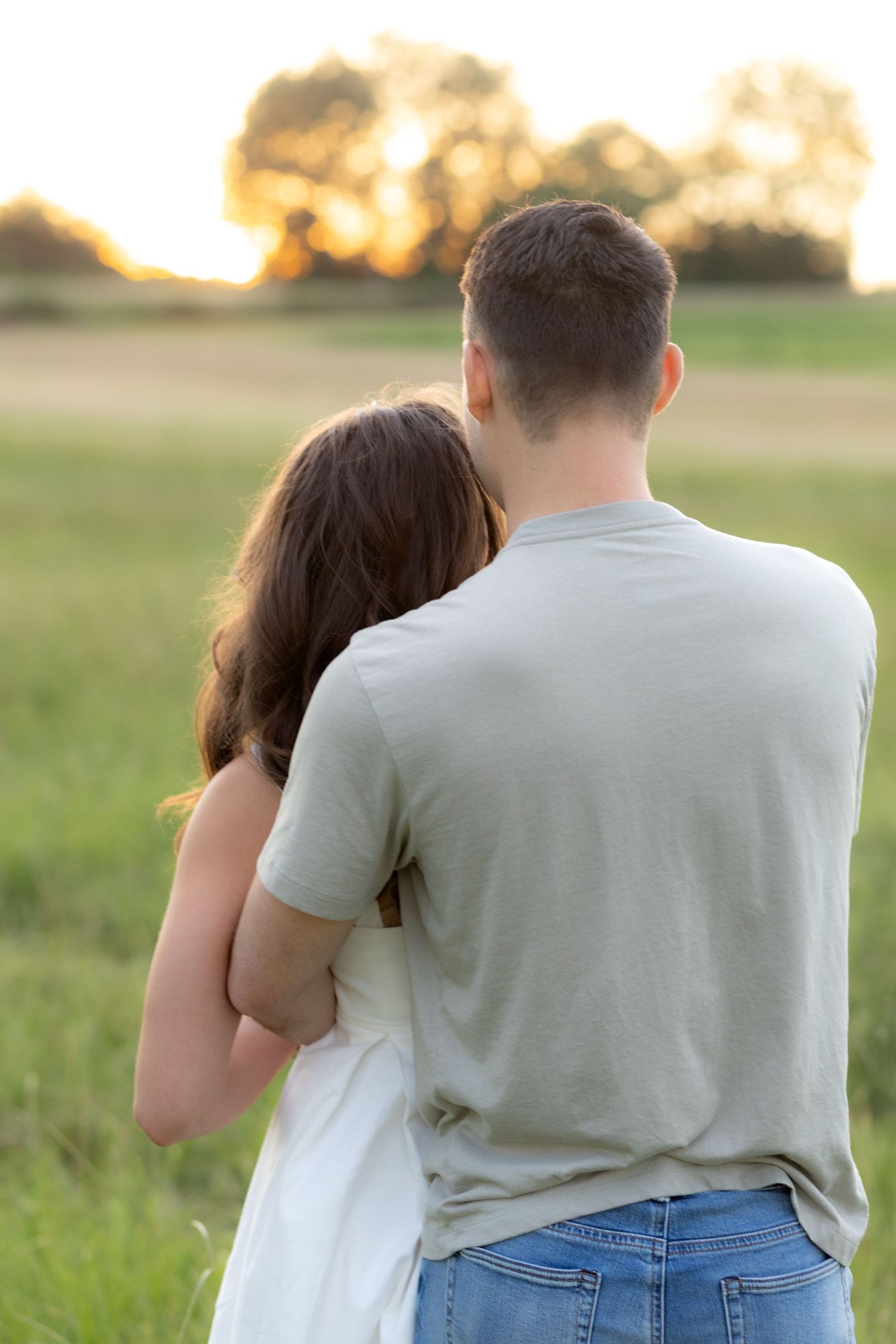 Couple holding each other in a grass field in Dothan, Alabama