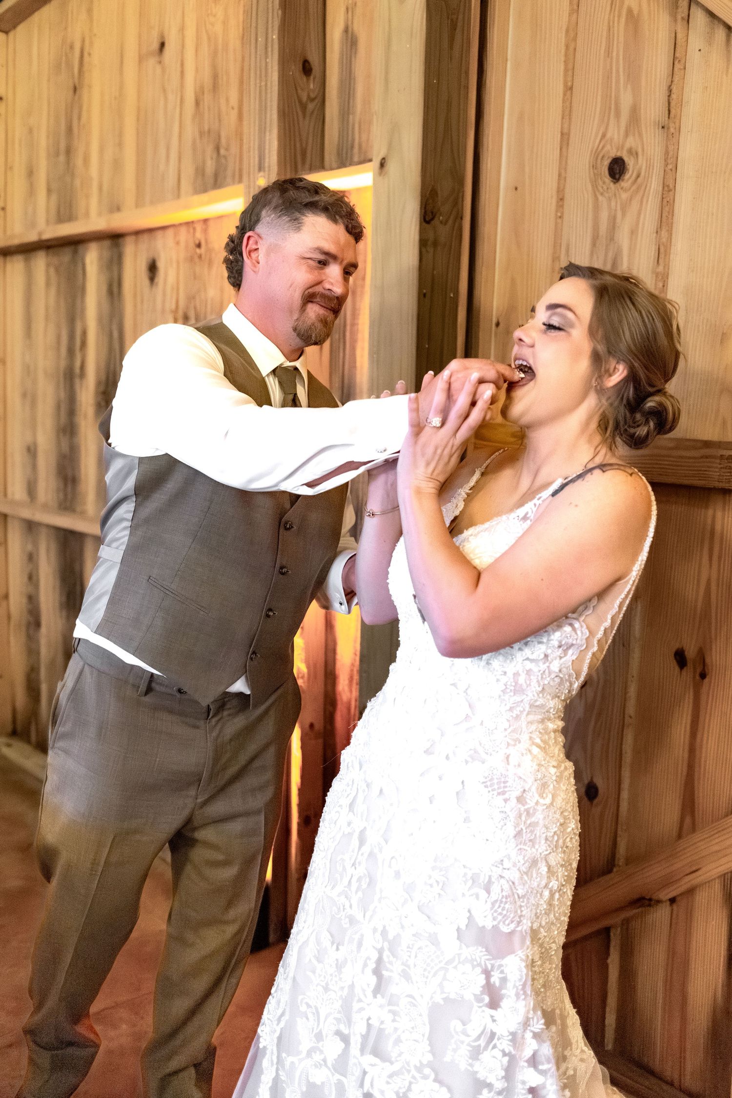 Bride and groom cut cake at their barn wedding at Hilltop Acres Wicksburg, Alabama