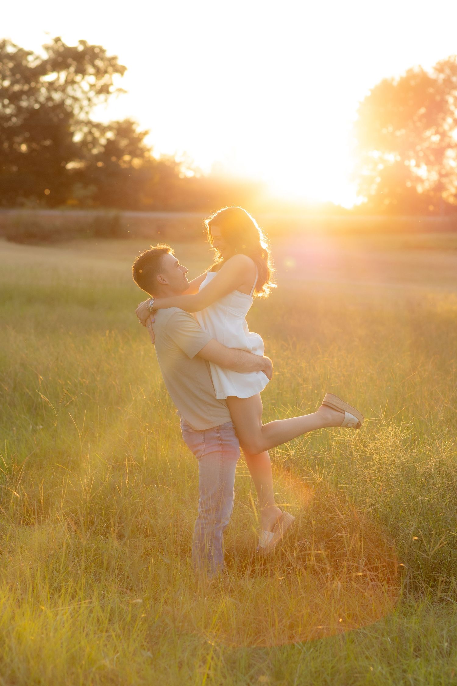 Couple holding each other in a grass field at sunset in Dothan, Alabama