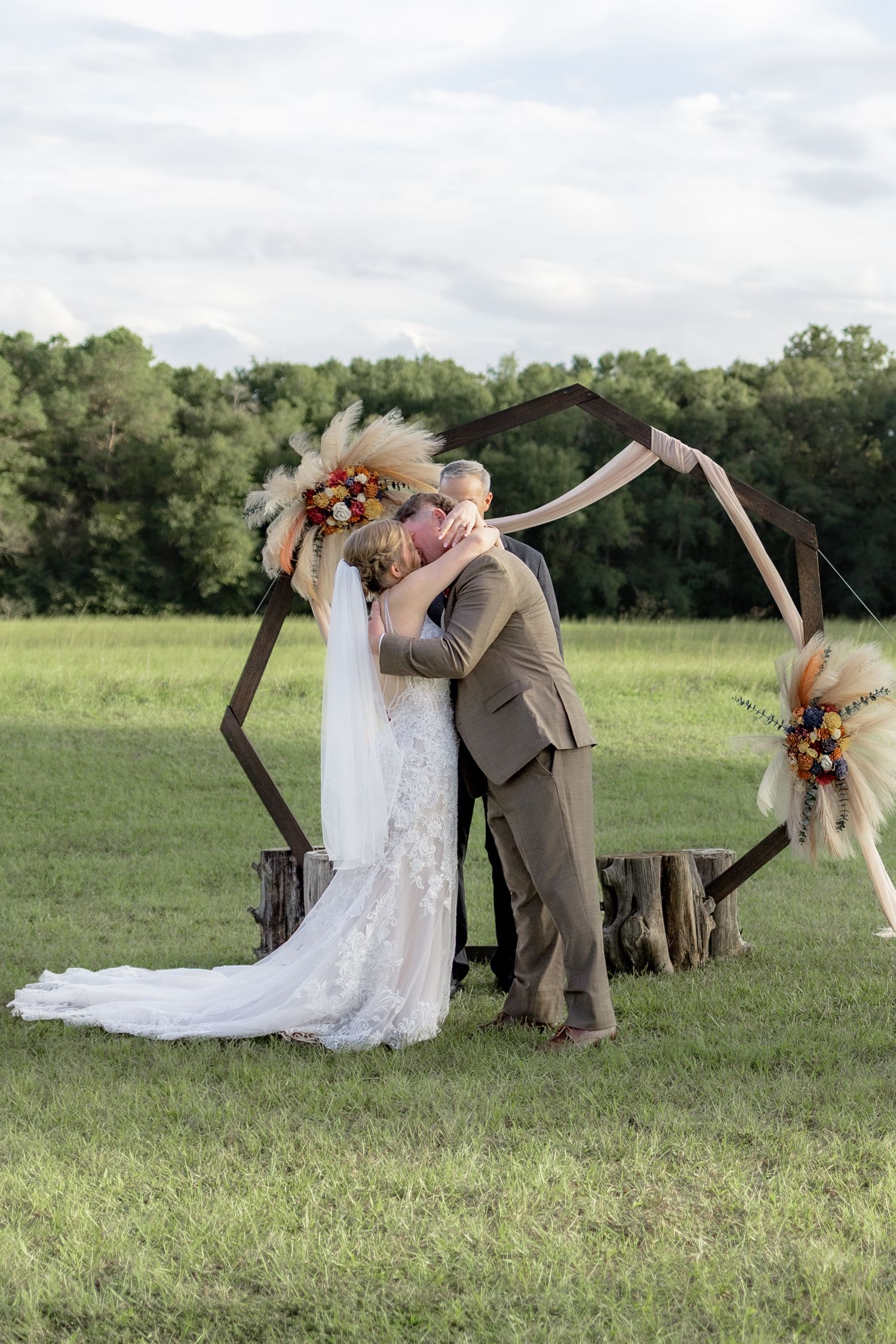 Bride and groom kiss at the altar after getting married at Hilltop Acres Wicksburg, Alabama