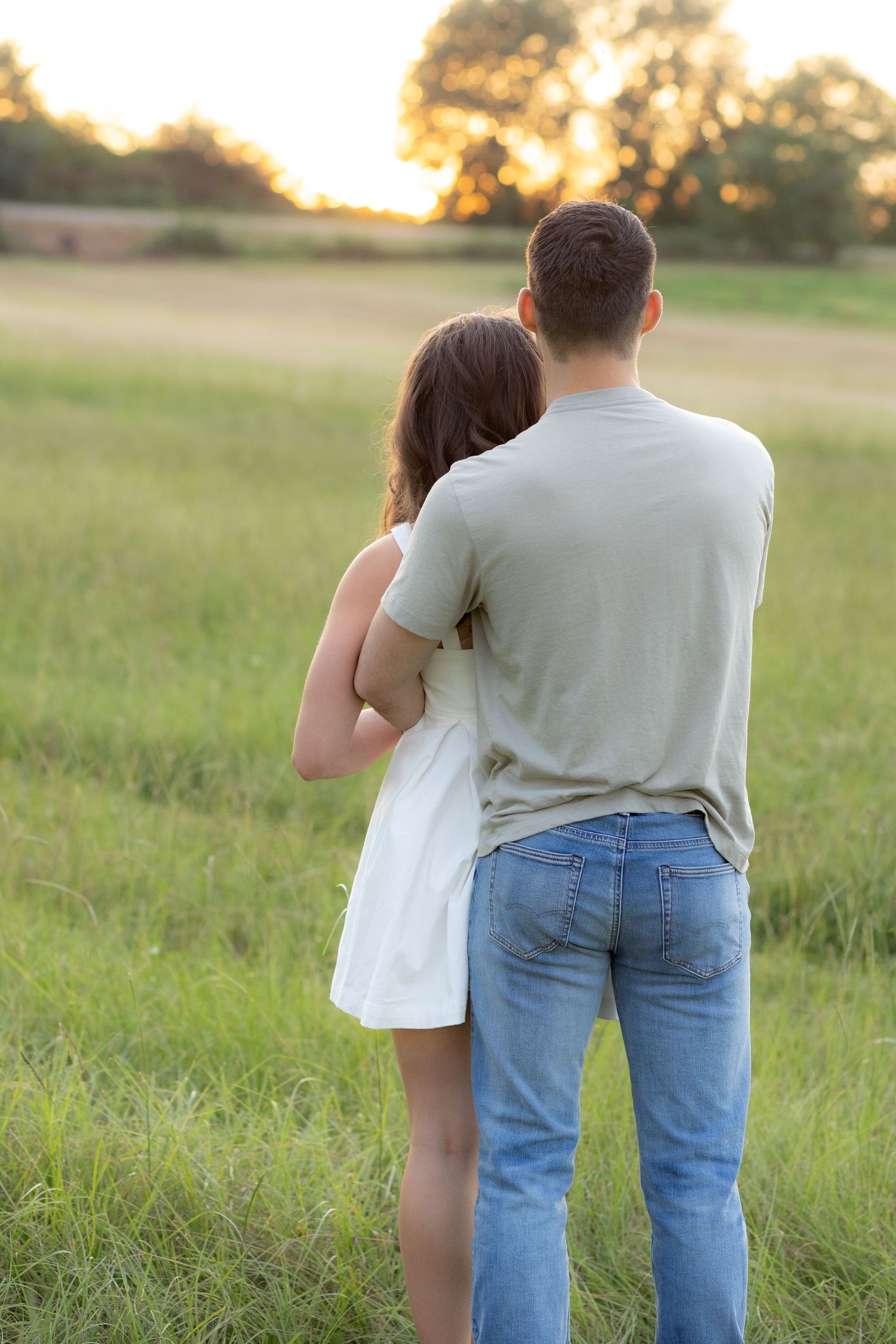 Couple holding each other in a grass field in Dothan, Alabama