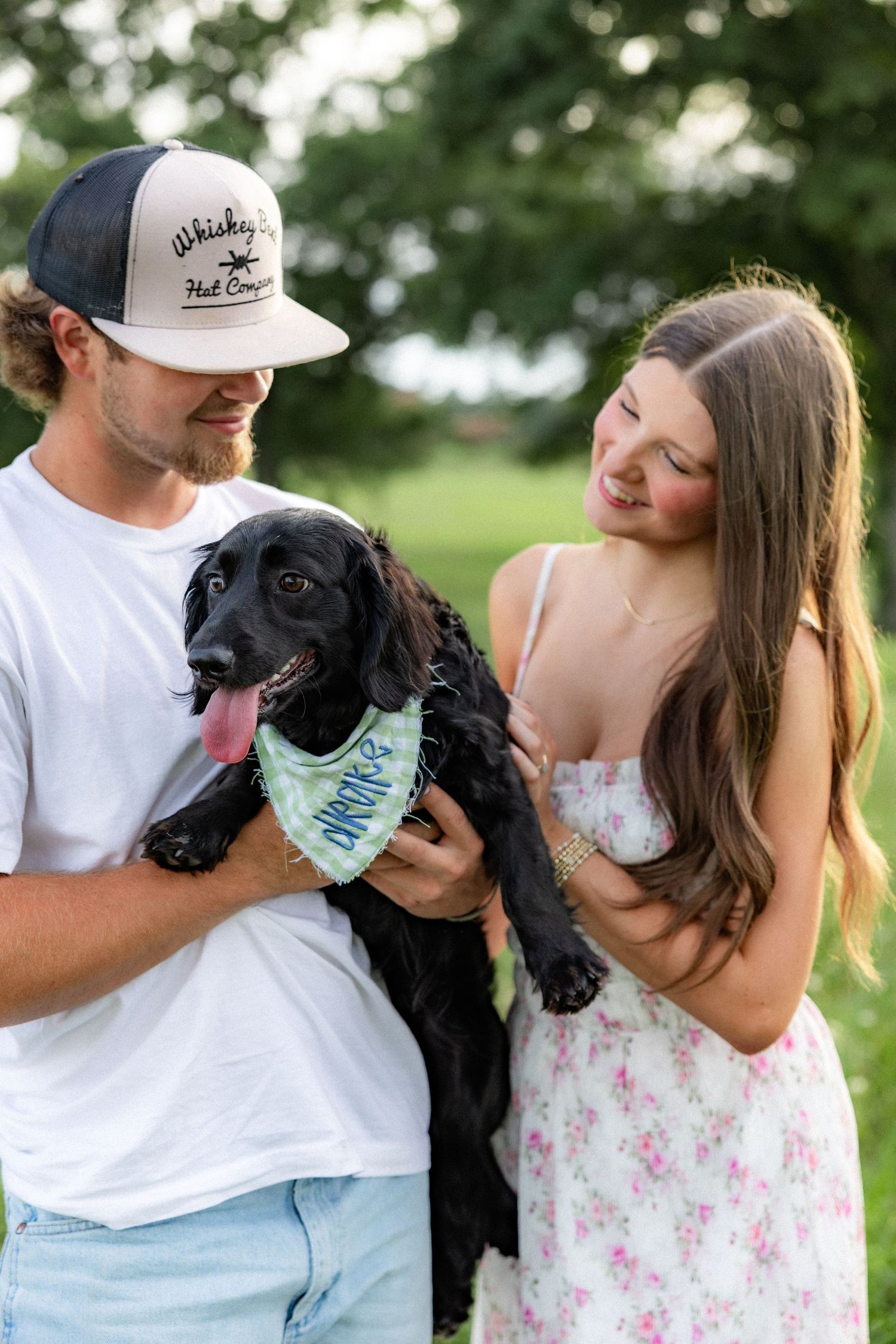Romantic couple photos in a natural grass field setting with large trees at sunset.