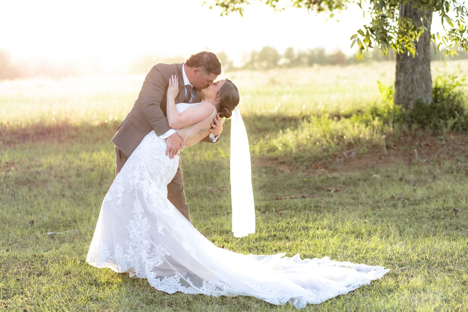 Bride and groom kidd at sunset at Hilltop Acres Wicksburg, Alabama
