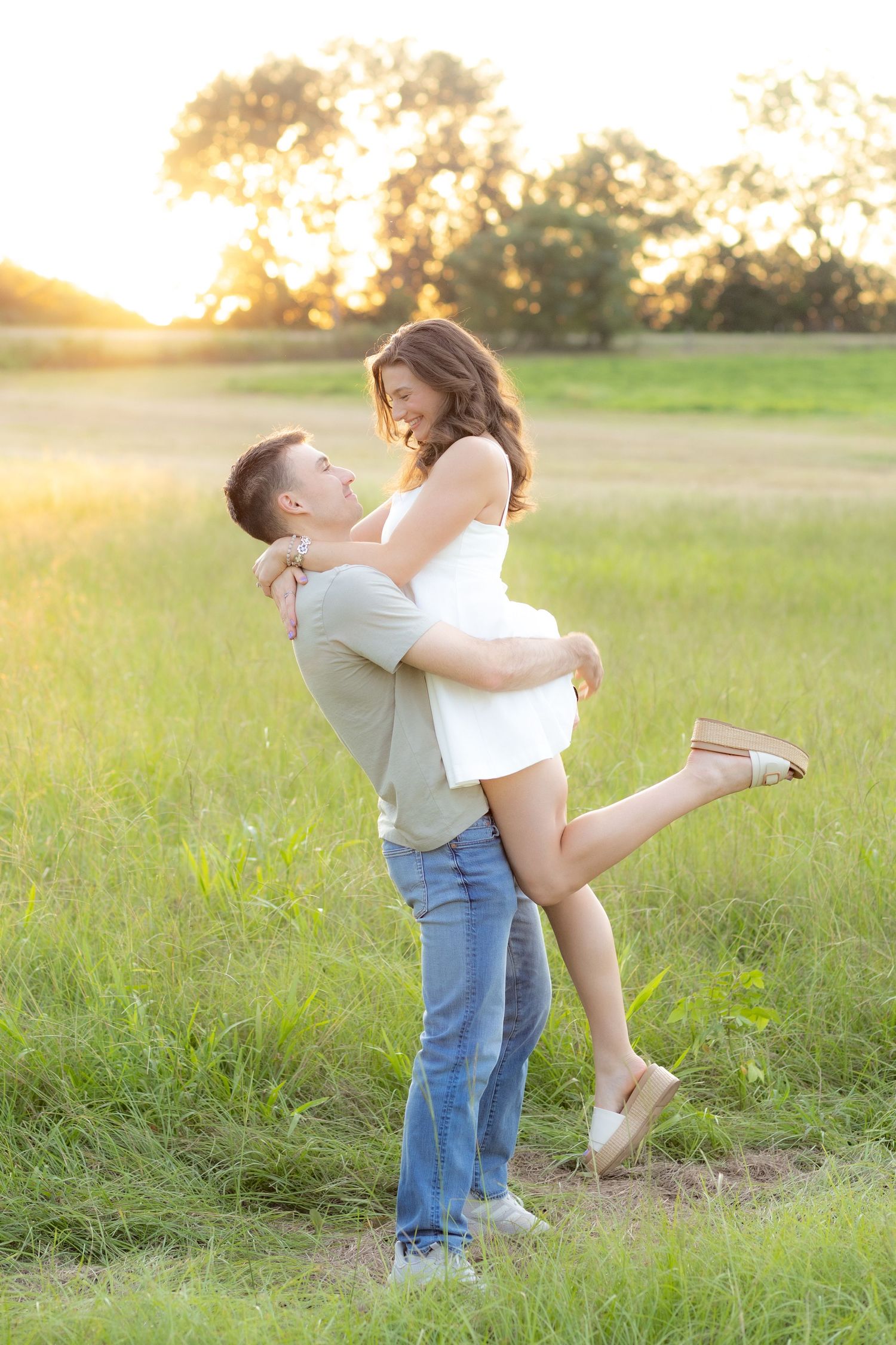 Couple dancing in a grass field at sunset in Dothan, Alabama