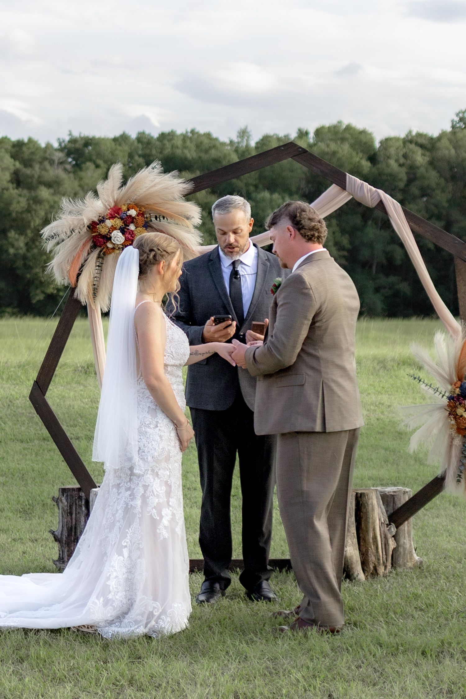 Bride and groom put on rings at their ceremony at Hilltop Acres Wicksburg, Alabama