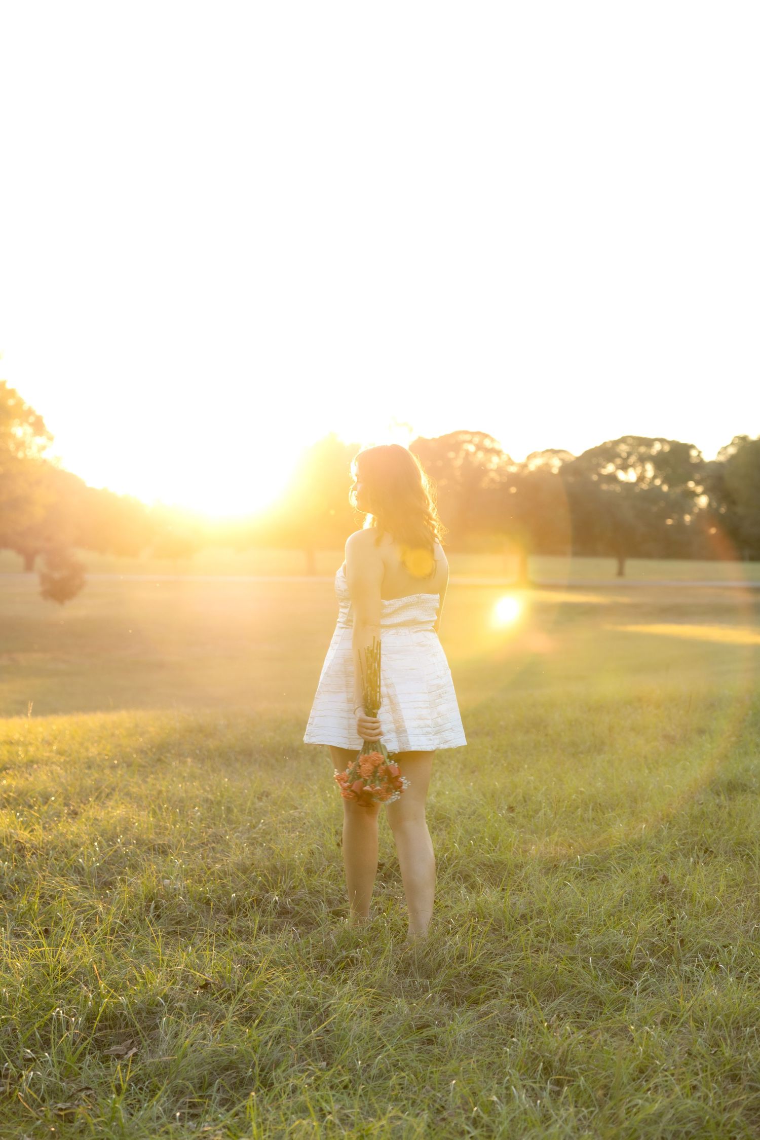 Senior pictures in a field at sunset at Troy University Dothan Campus