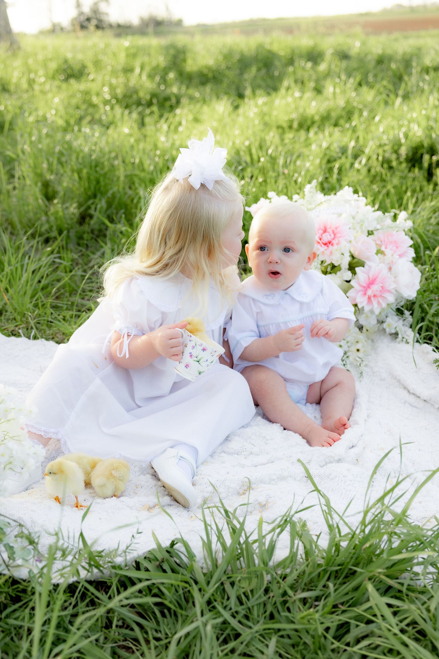 Spring Mini Session with baby chicks in a grass field at sunset near Dothan, Alabama