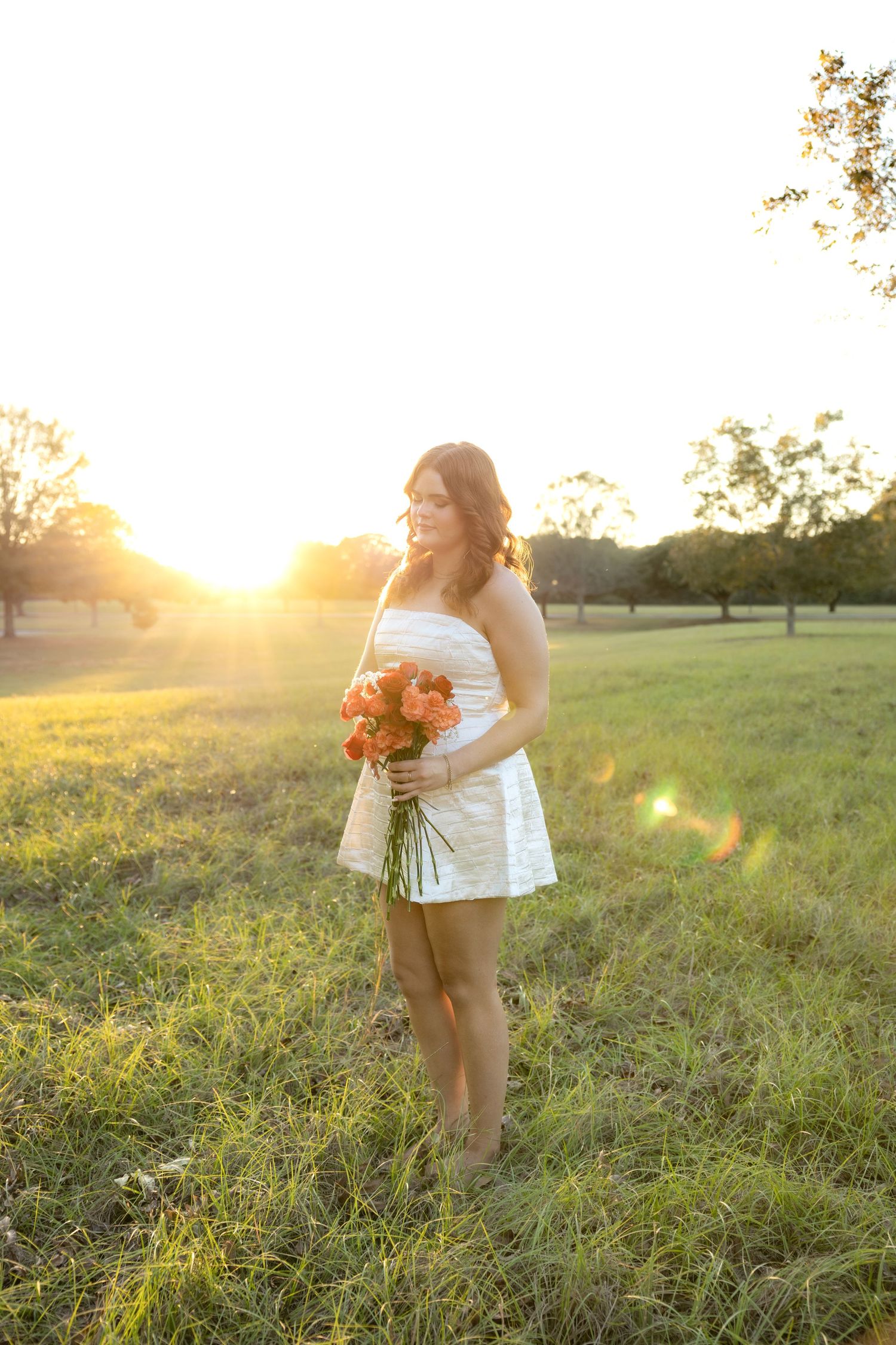 Senior pictures in a field at sunset at Troy University Dothan Campus