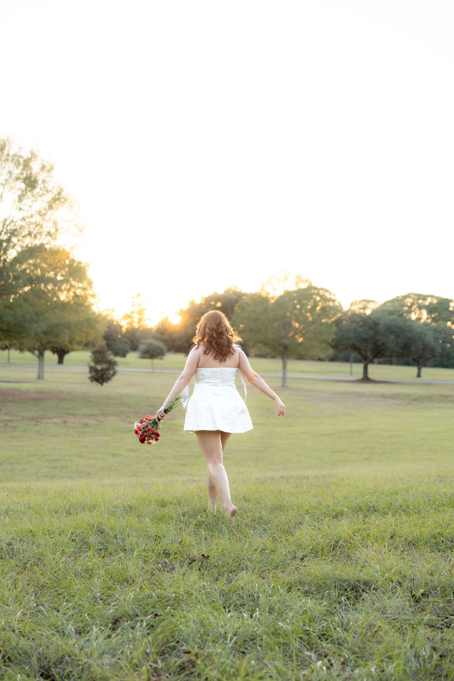 Senior running through a field at sunset at Troy University Dothan Campus