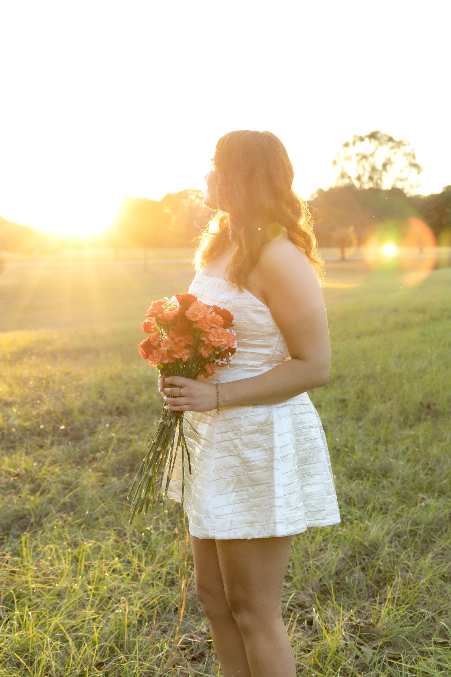 Senior pictures in a field at sunset at Troy University Dothan Campus