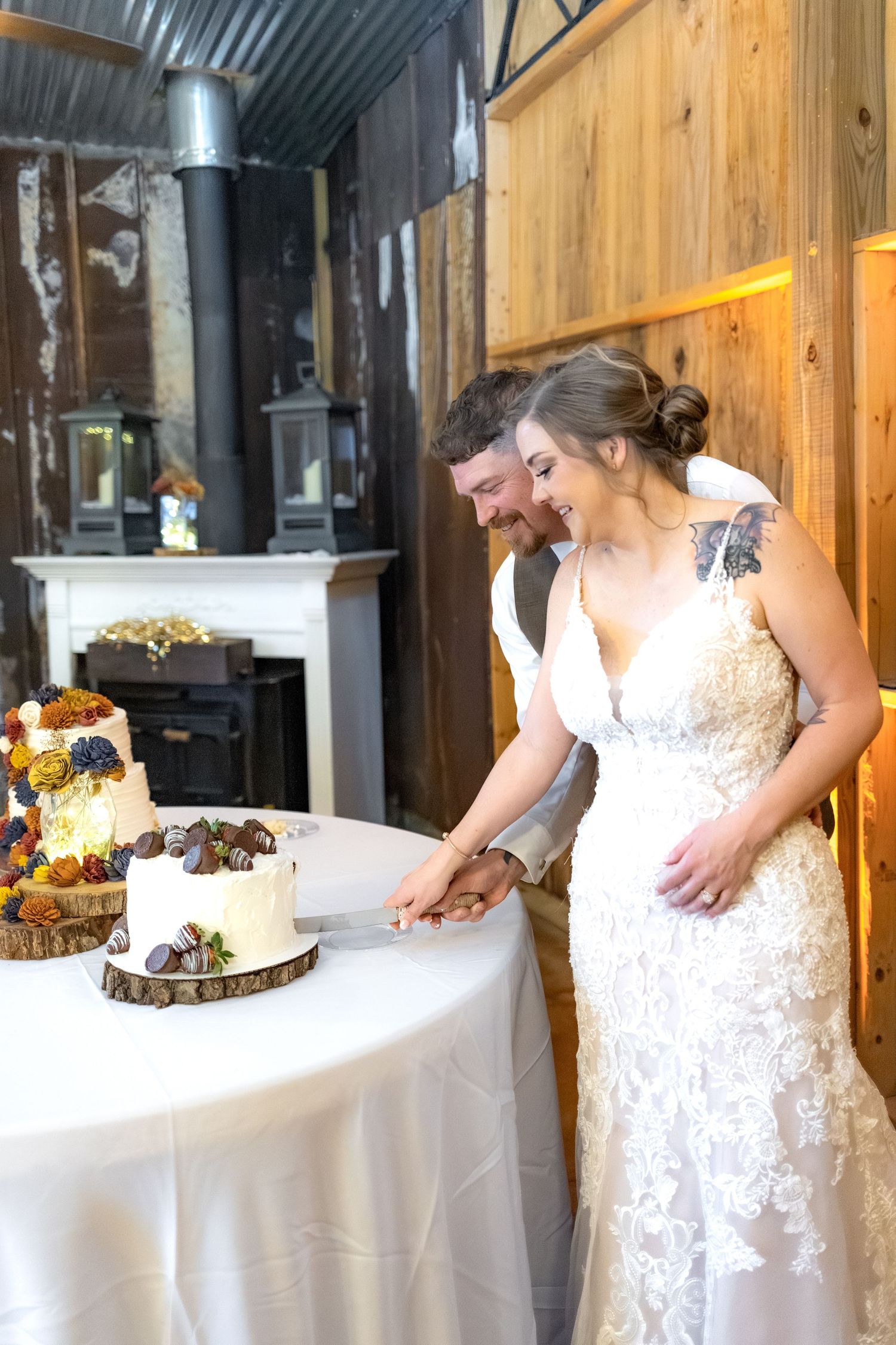 Bride and groom cut cake at their barn wedding at Hilltop Acres Wicksburg, Alabama