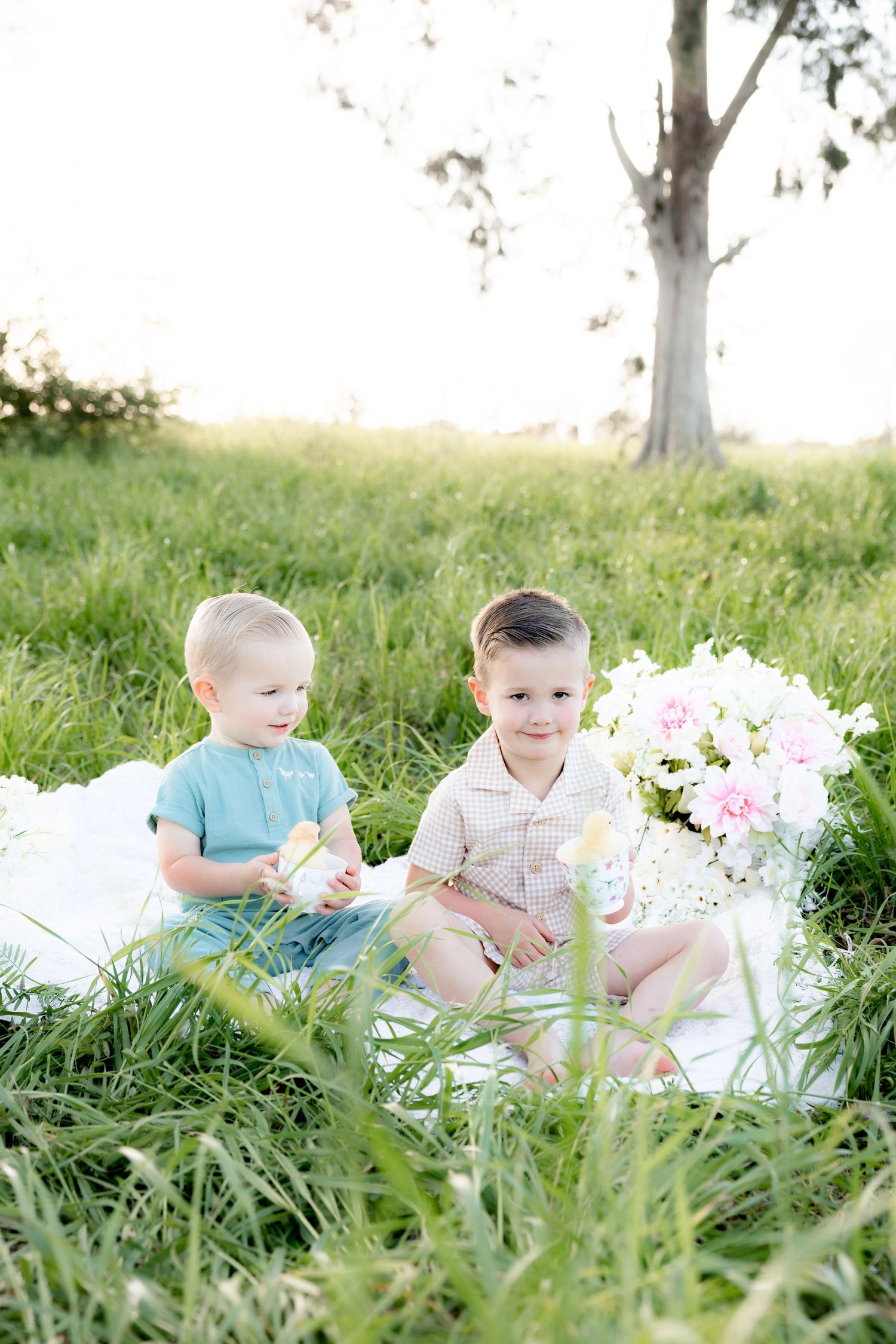 Spring Mini Session with baby chicks in a grass field at sunset near Dothan, Alabama