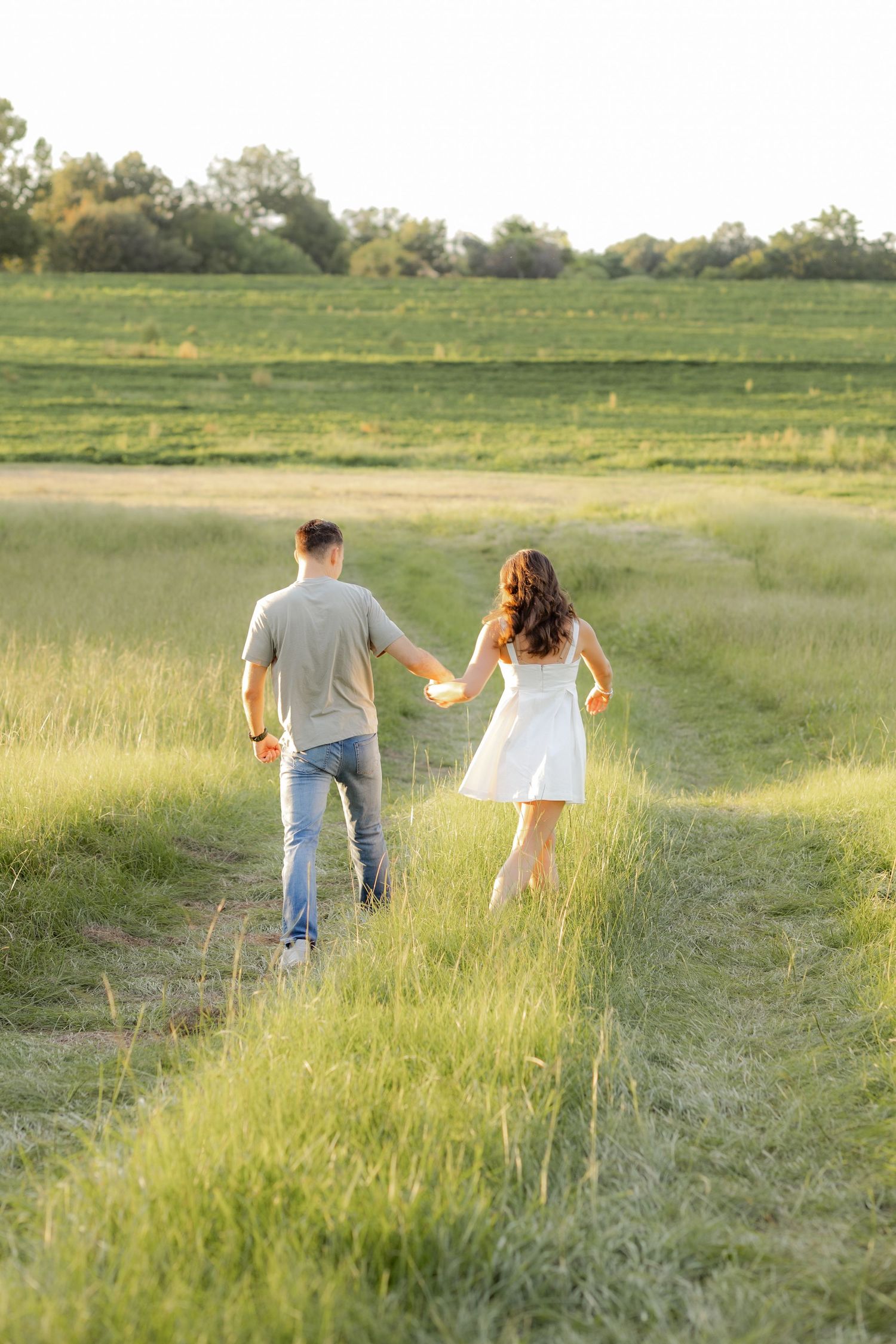Couple walking in a grass field at sunset in Dothan, Alabama