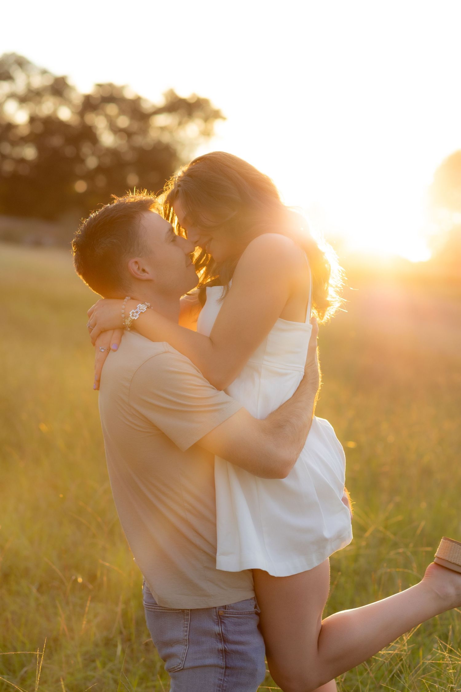 Couple holding each other in a grass field at sunset in Dothan, Alabama