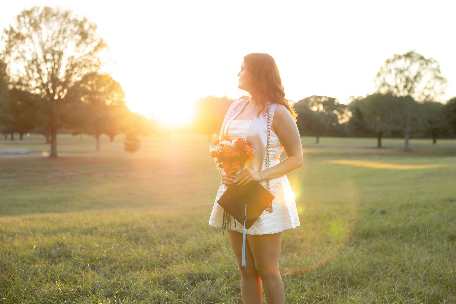 Senior pictures in a field at sunset at Troy University Dothan Campus
