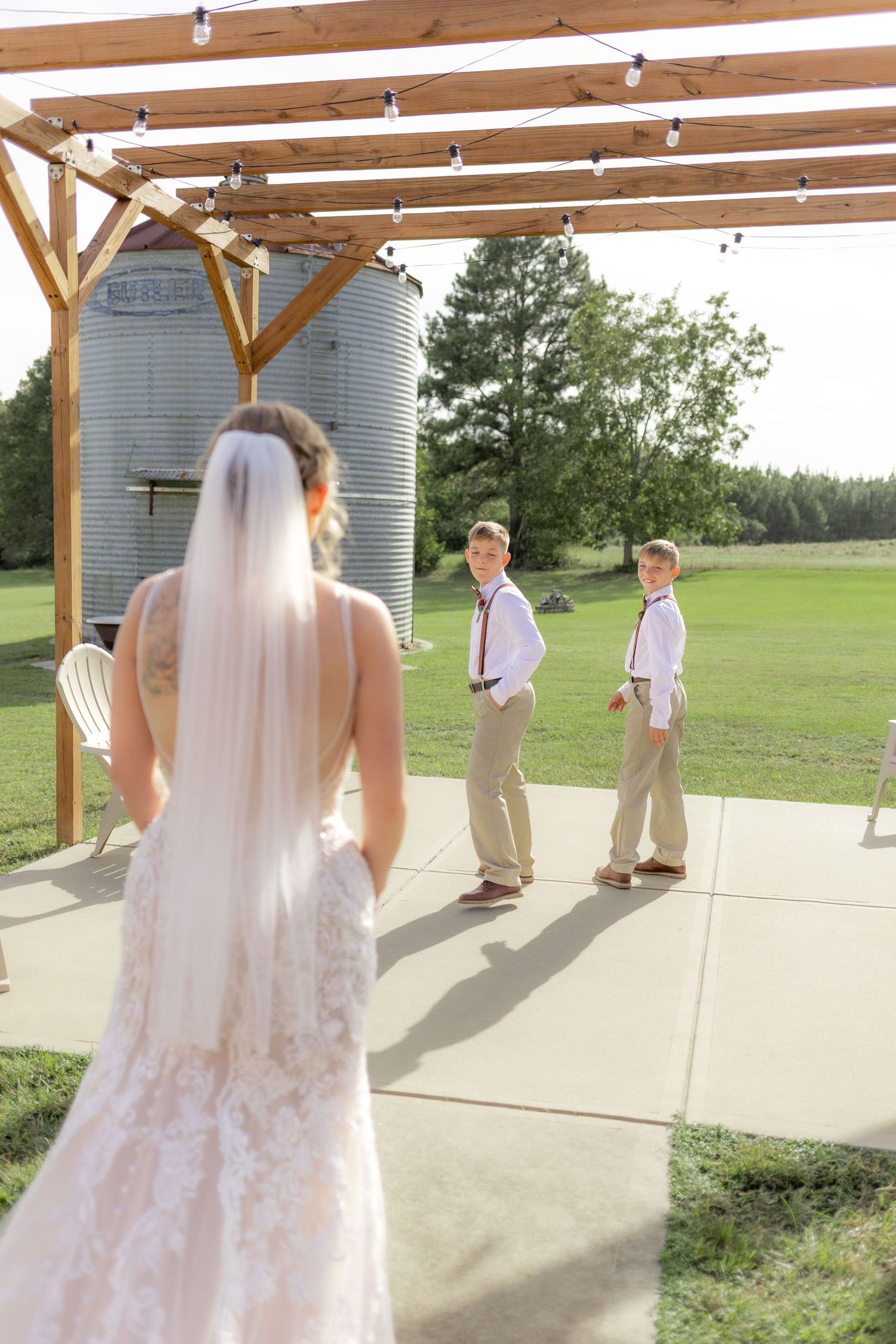 Sons' first look with bride underneath the gazebo at Hilltop Acres Wicksburg, Alabama