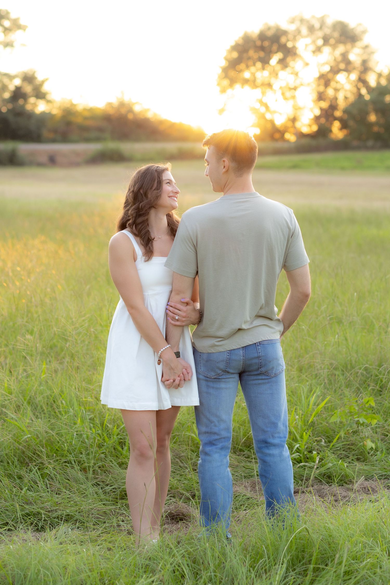 Couple holding each other in a grass field at sunset in Dothan, Alabama