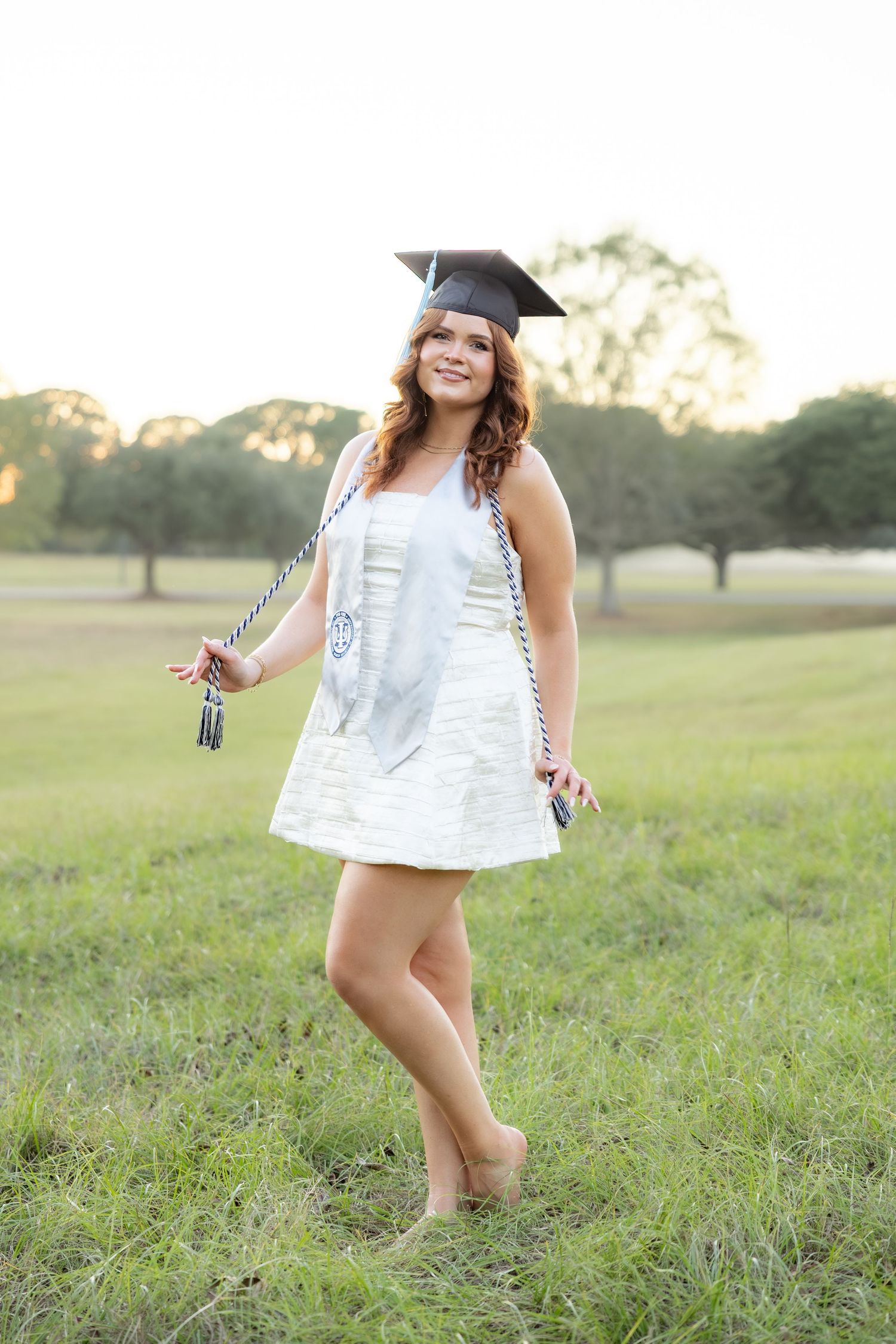 Senior pictures at sunset in a field at Troy University Dothan Campus