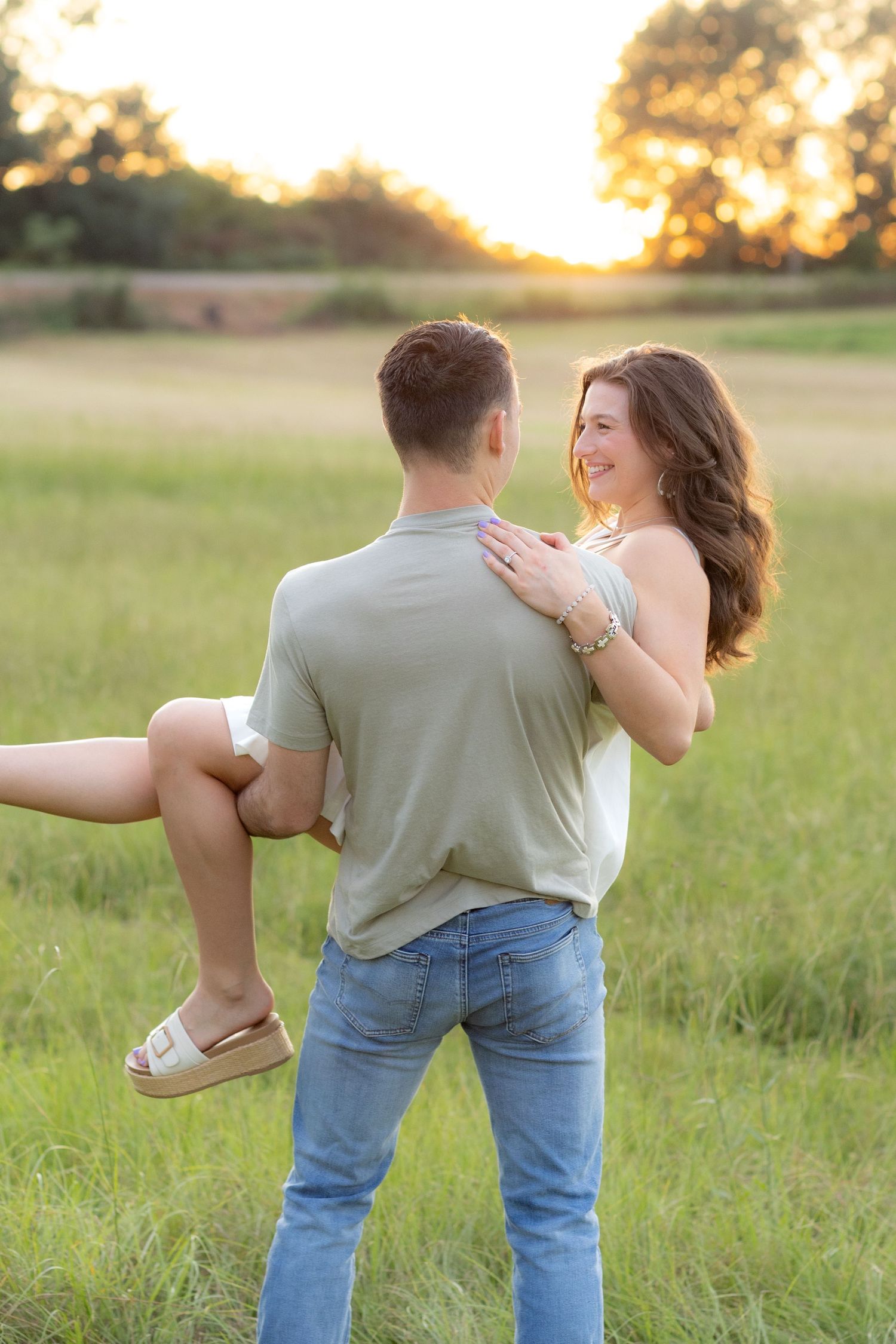 Couple holding each other in a grass field in Dothan, Alabama